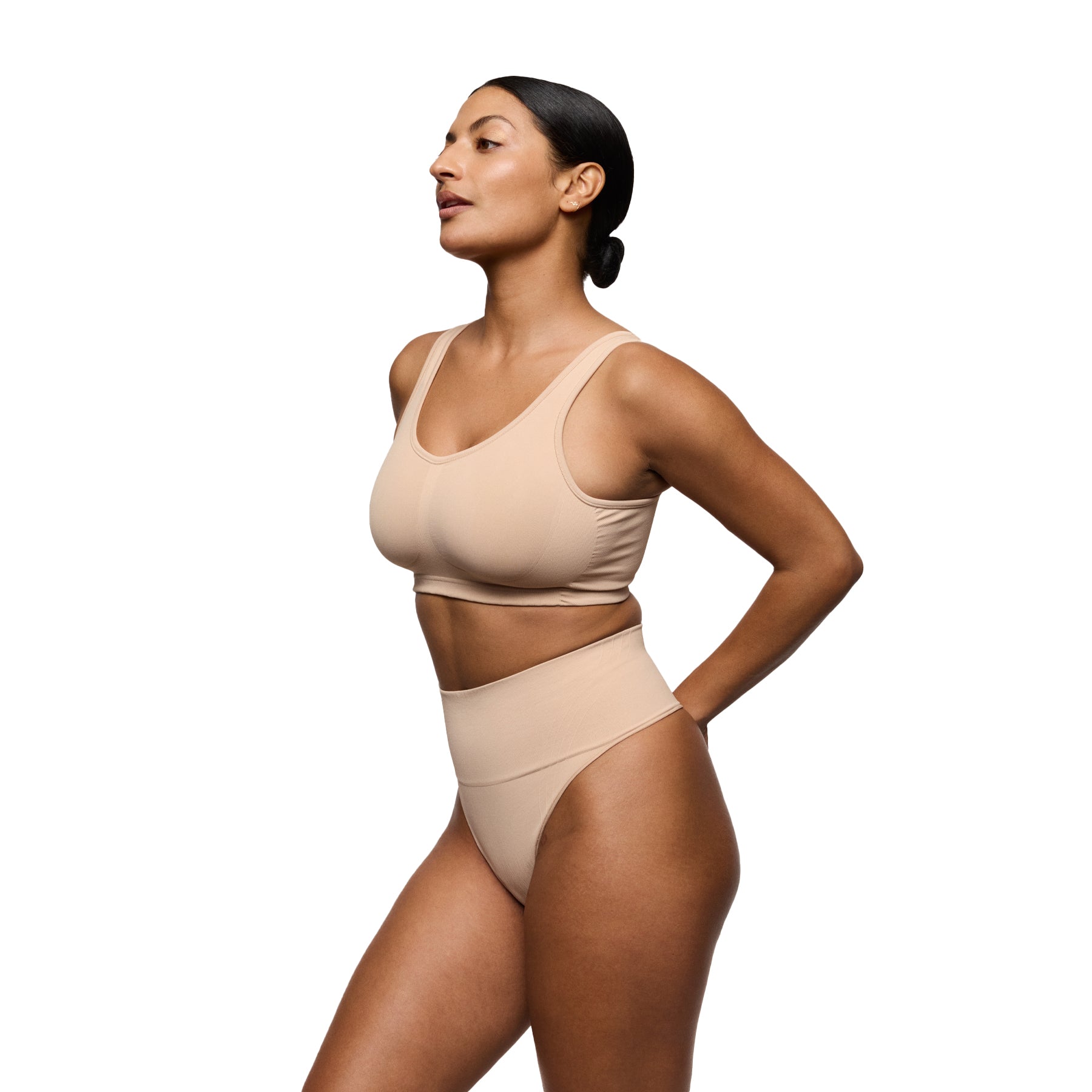 Woman wearing a beige Thong on a white background