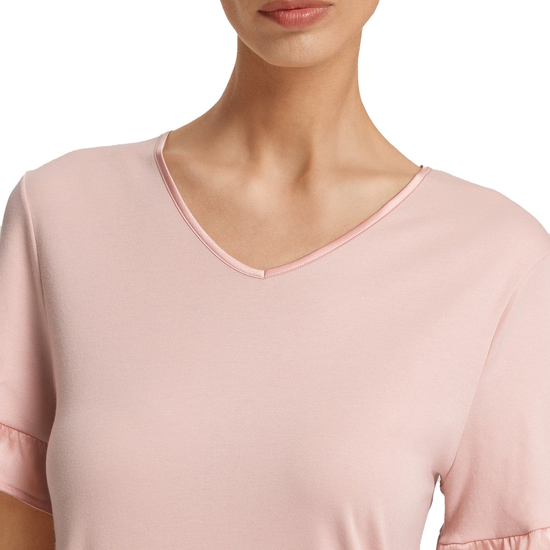 Close-up of V-neckline on blush pink nightdress showing smooth fabric and soft satin trim.