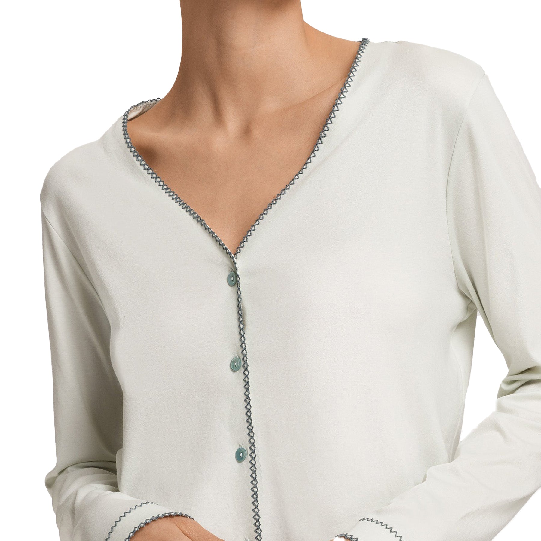 Close-up of a light-colored cardigan with button details on a white background