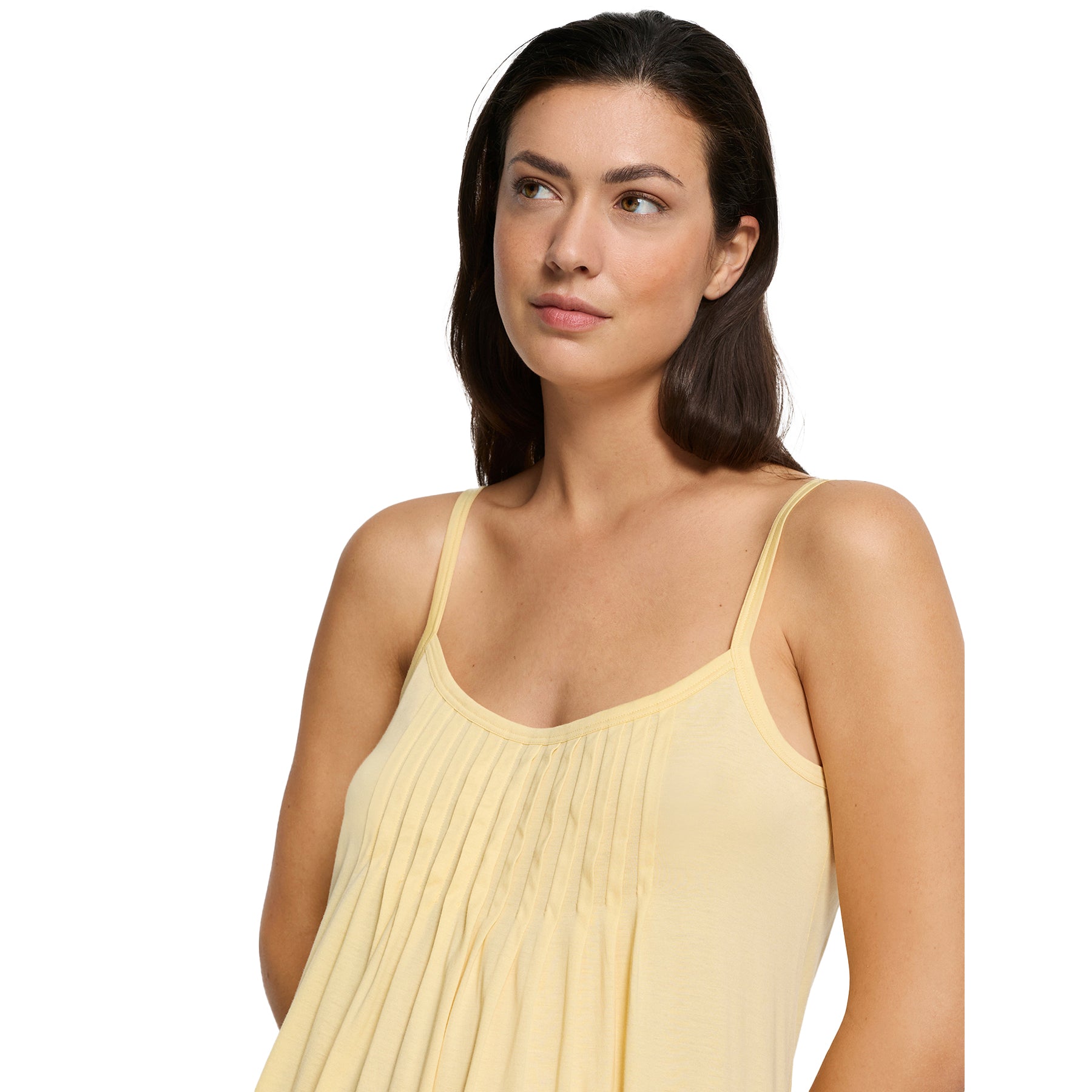 Pale yellow sleeveless nightgown with thin straps and pleated front, close-up on model