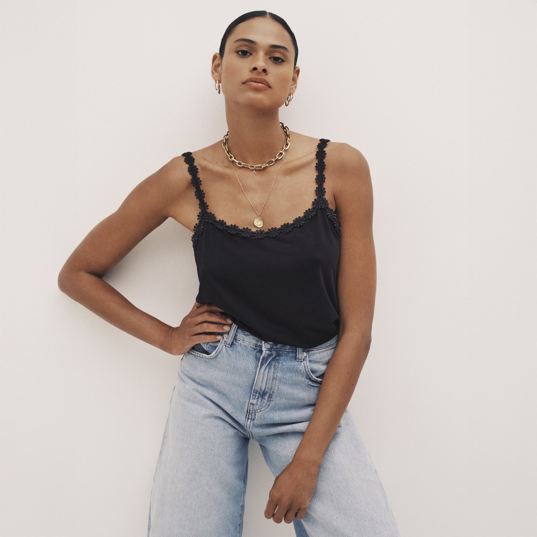 Black lace-trim camisole styled with jeans for elevated everyday wear