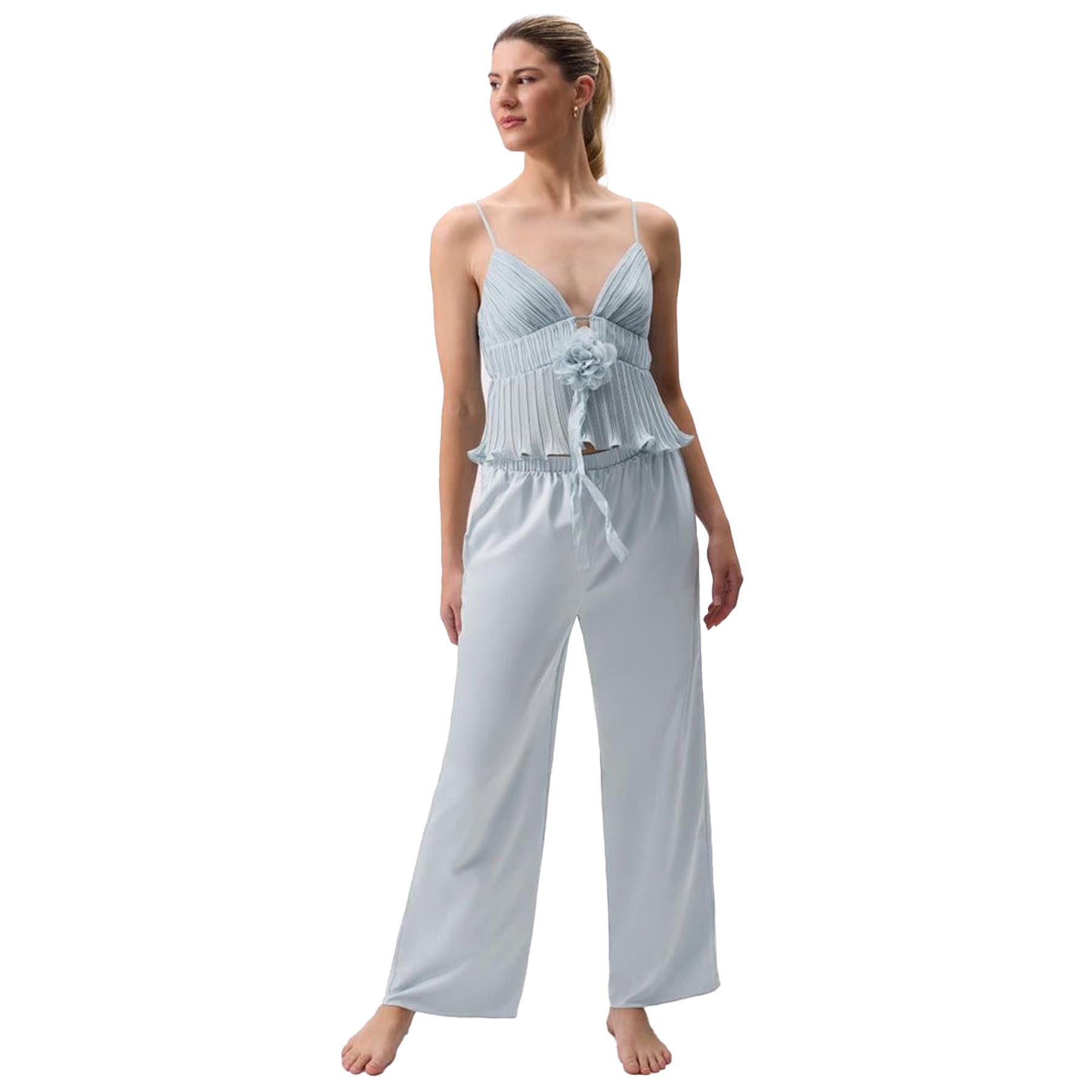 Front view of light blue camisole pajama set with pleated bodice, floral detail, and satin trousers.