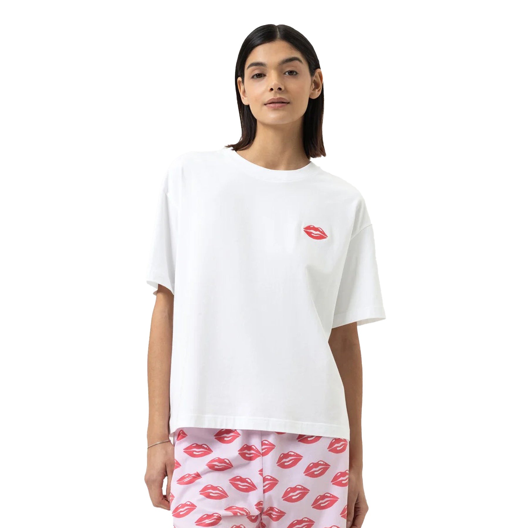 Model wearing white T-shirt with red lip motif and pink jogger pants printed with red lips.