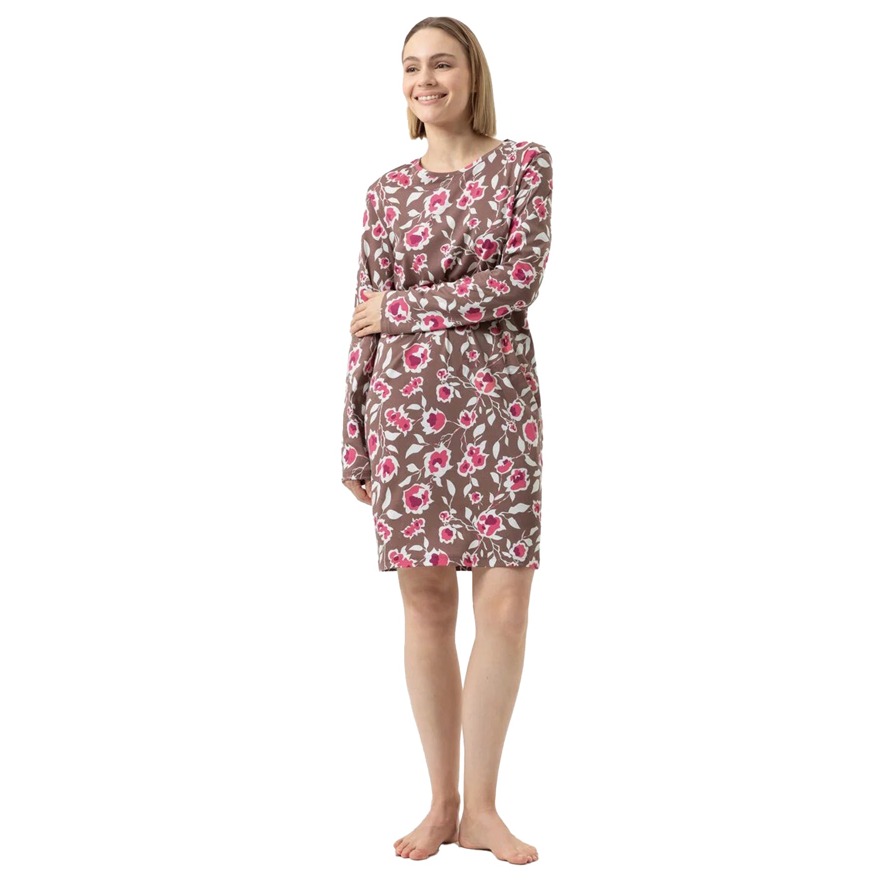 Woman wearing long-sleeve floral print nightgown in taupe with pink and white flowers.