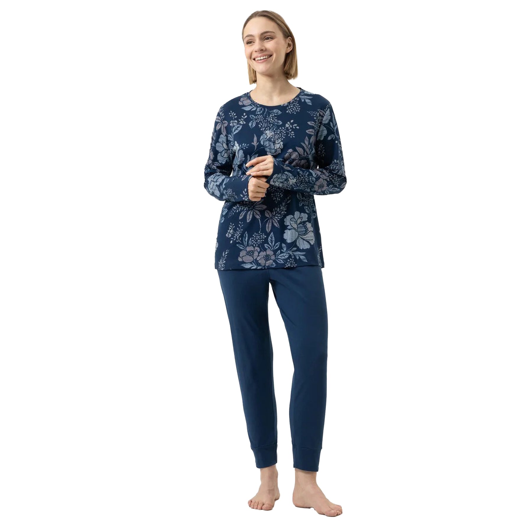 Woman wearing a navy floral long-sleeve top and pants on a white background