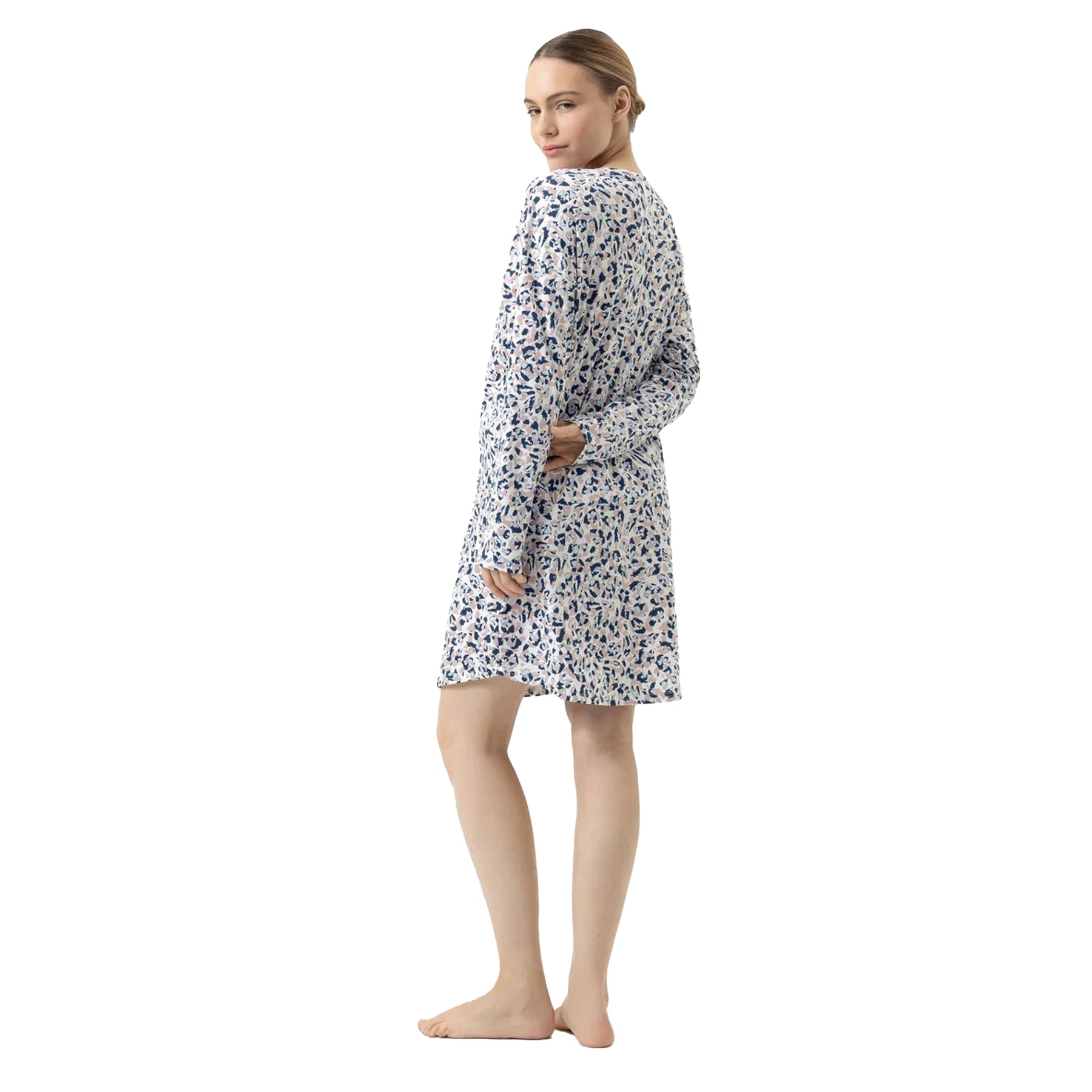 Back view of woman wearing a white long-sleeve nightgown with navy and beige abstract pattern.