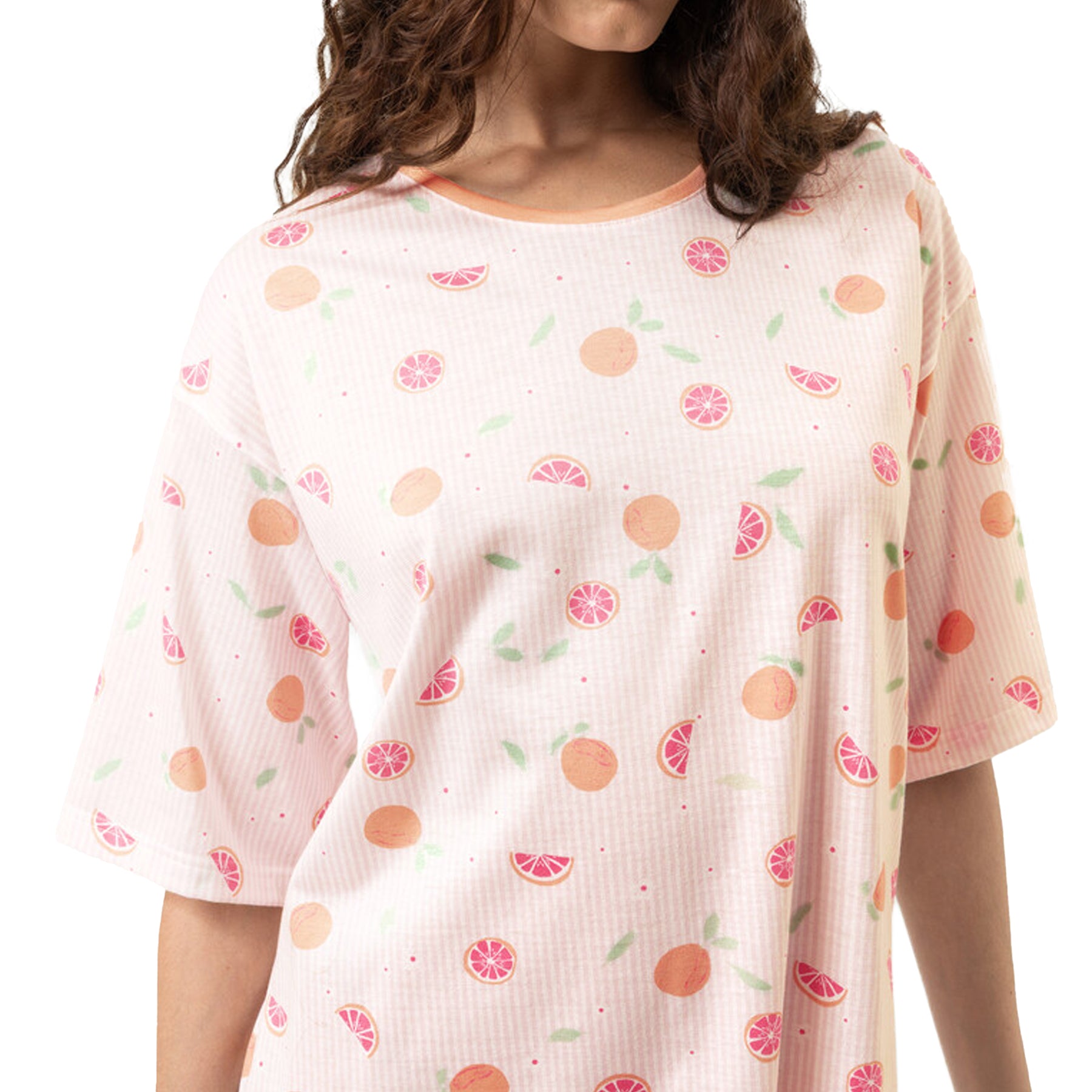 Close-up of peach and grapefruit print sleep dress on soft striped fabric