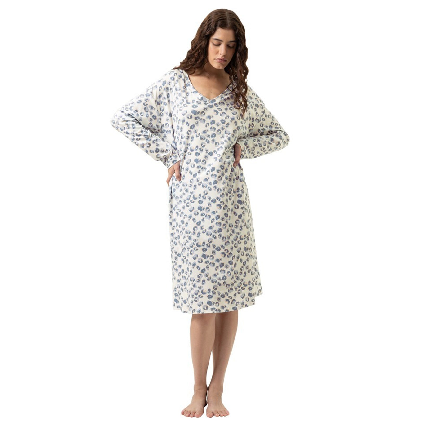 Woman wearing a long-sleeve V-neck nightdress in an ivory base with soft blue and taupe leopard print, knee-length, relaxed fit.