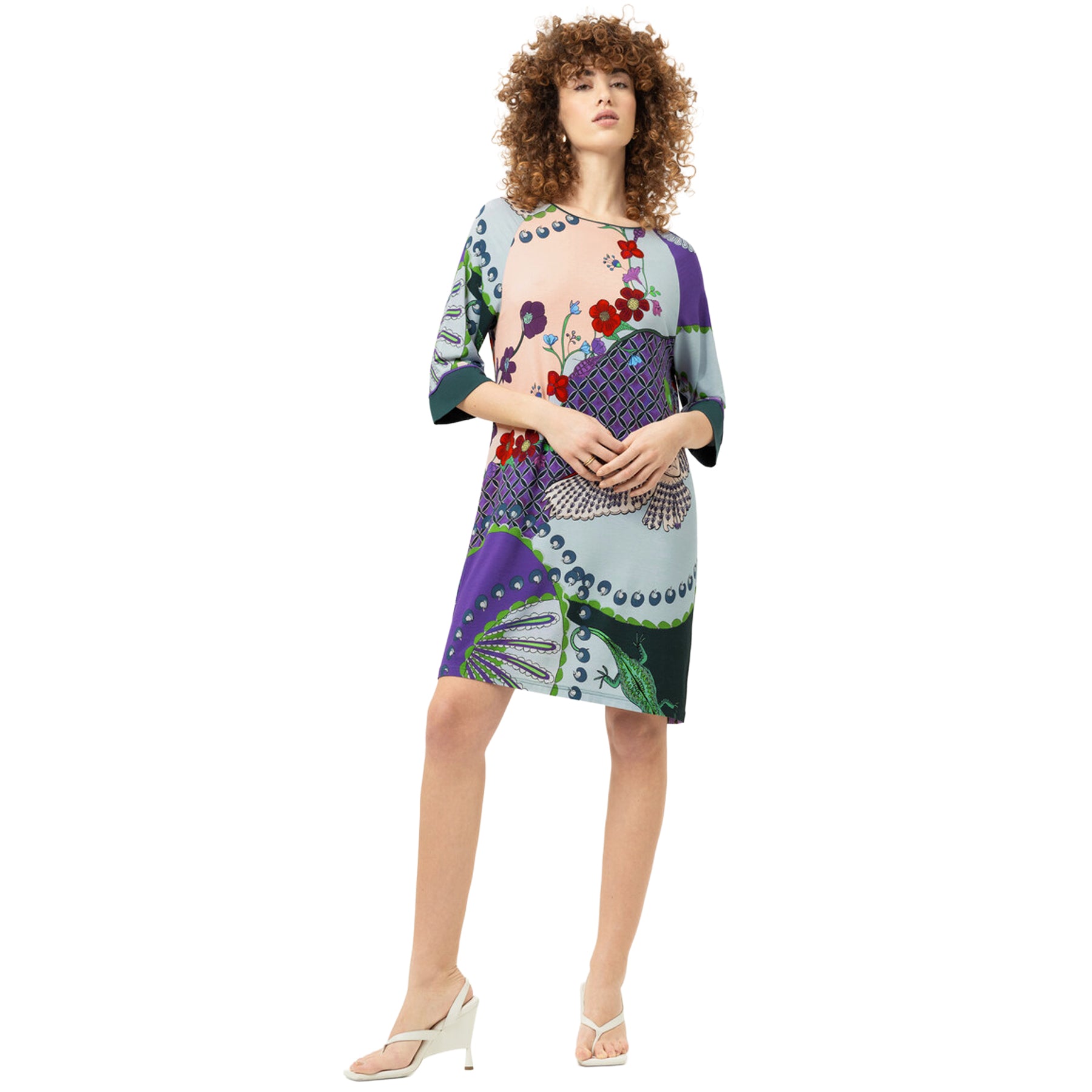 Model wearing the Mey Secret Glade sleep shirt styled as a casual lounge dress, featuring a vibrant botanical print, relaxed fit, and elegant three-quarter sleeves.