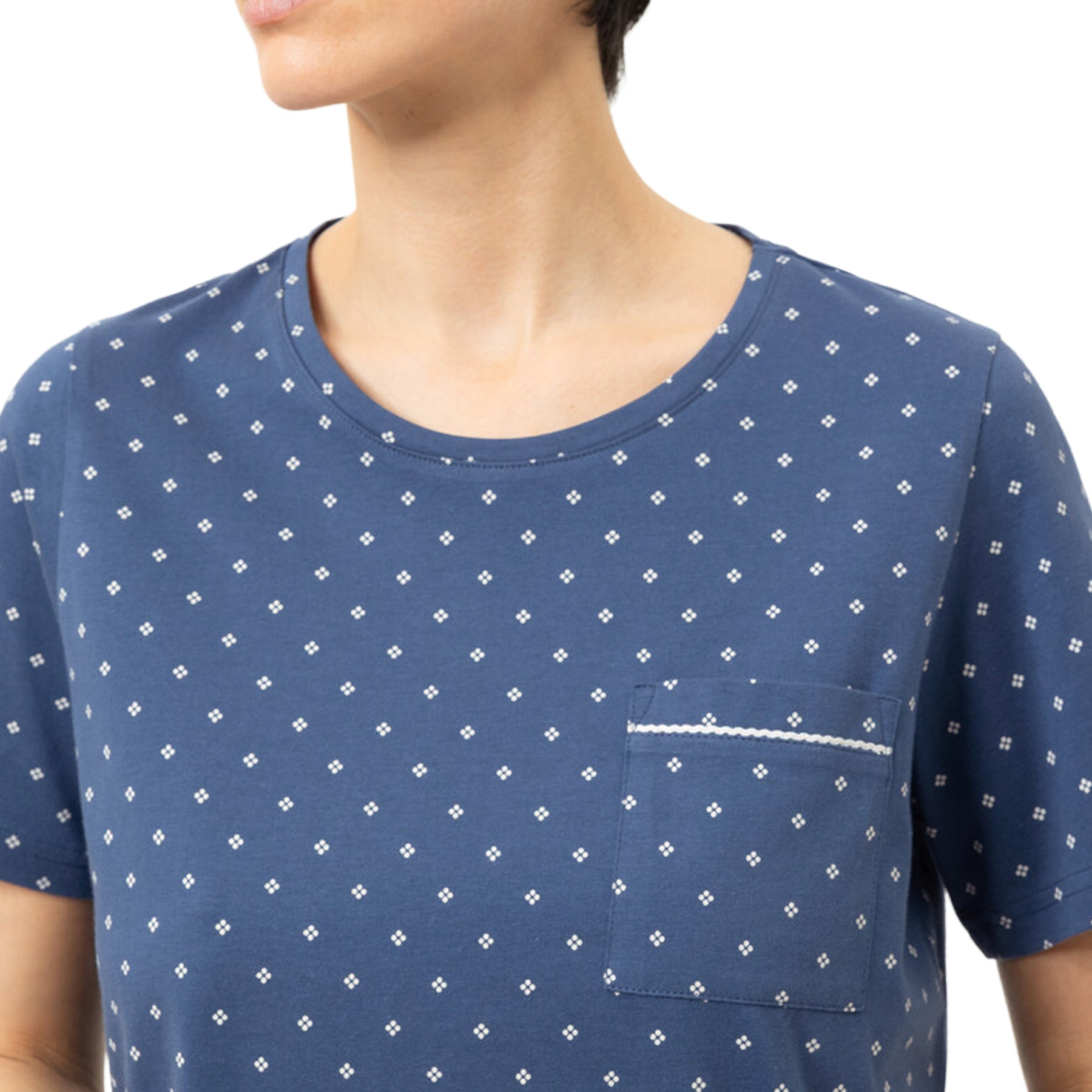 Close-up of the Mey Midnight Dust sleepshirt showing the round neckline, chest pocket with decorative trim, and soft blue geometric print fabric.