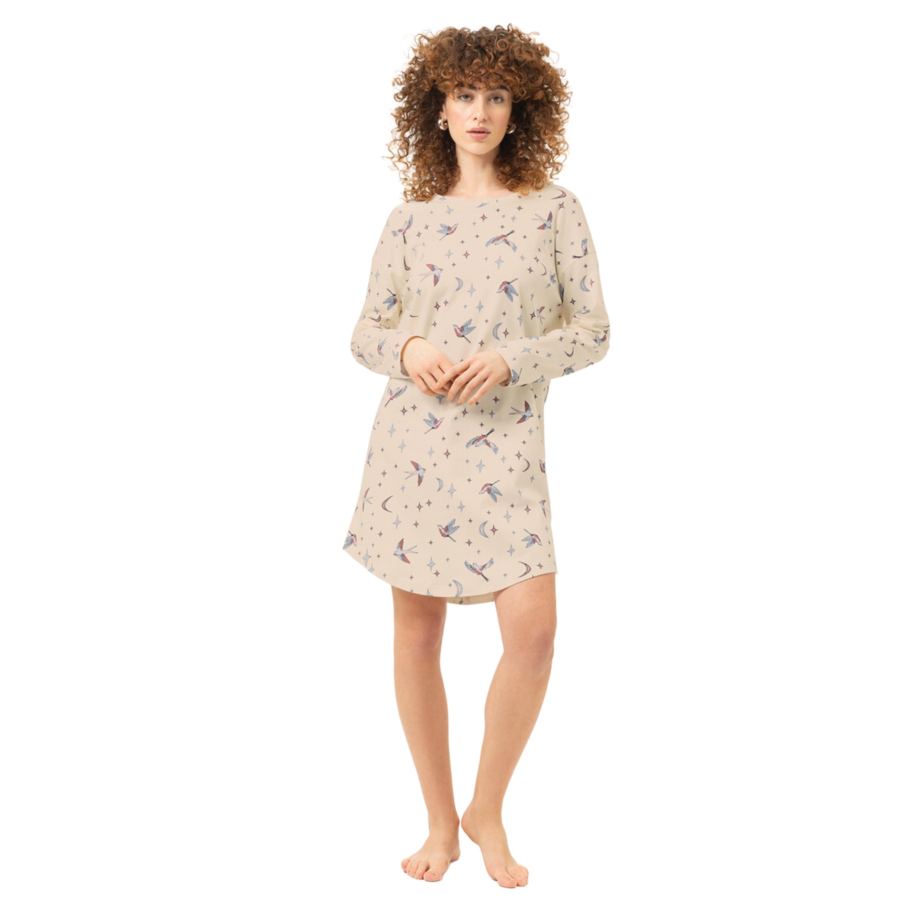 Front view of woman wearing a cream long-sleeve nightgown with an all-over bird, crescent moon and star print and relaxed fit.