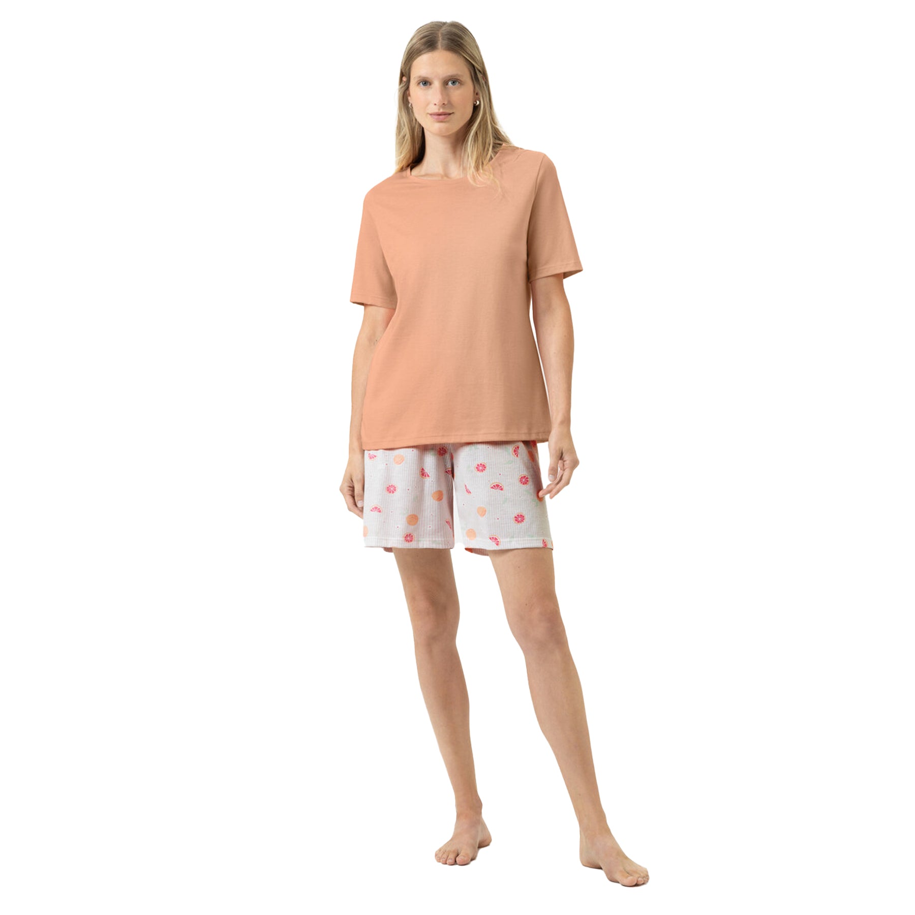 Woman wearing peach short sleeve sleep top with citrus fruit print shorts pyjama set
