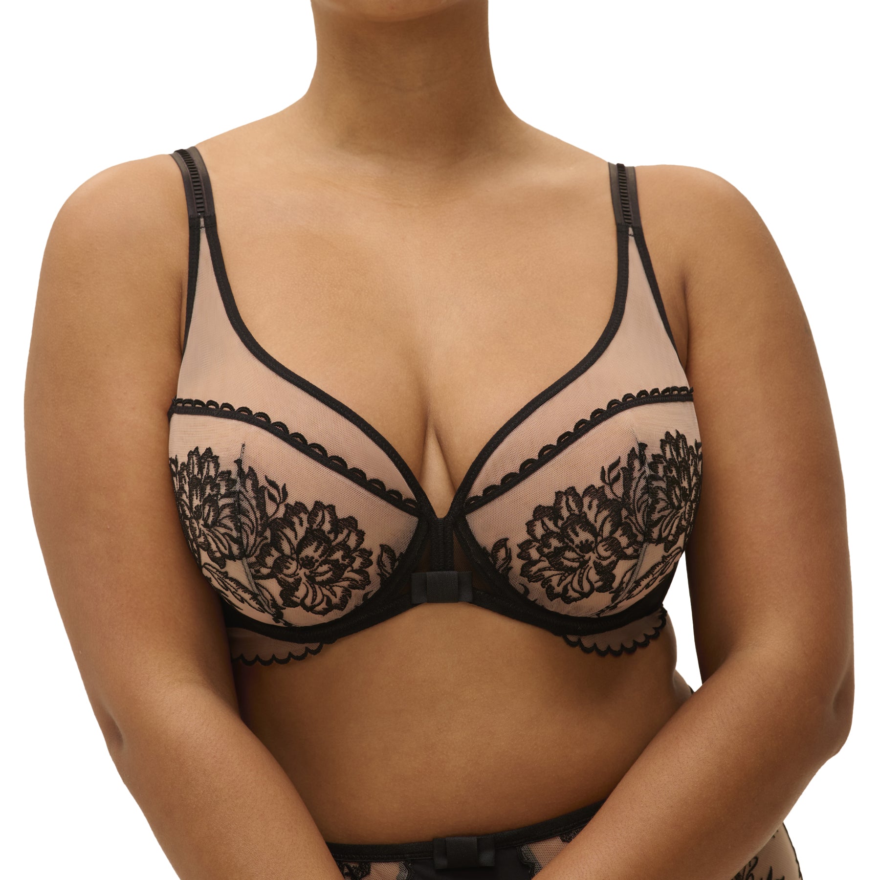 Black sheer bra with floral embroidery and scalloped edges, worn by model, front close-up.