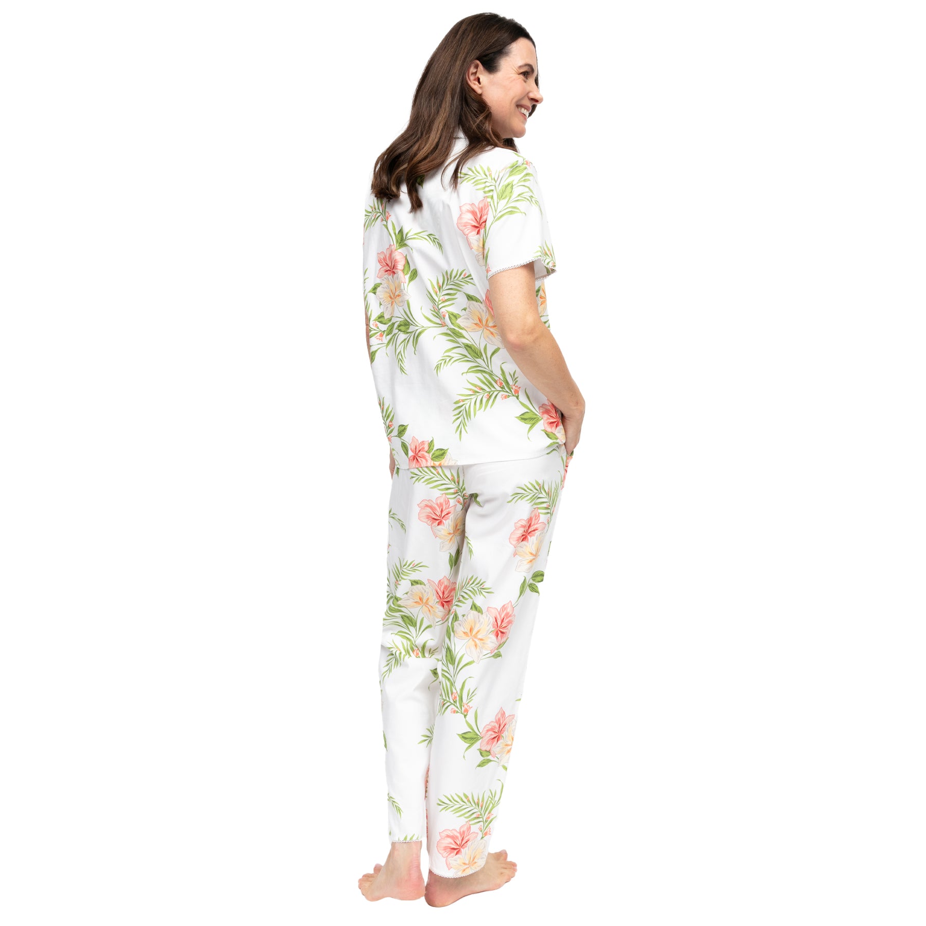 Women’s white floral cotton pyjama set, back view, featuring soft pink hibiscus and green leaf print with short sleeve button-up top and relaxed straight-leg pants