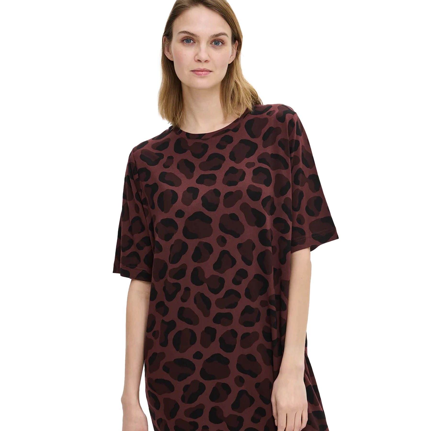 Woman wearing a burgundy leopard-print nightdress, showing the round neckline, short sleeves, and smooth cotton fabric detail.