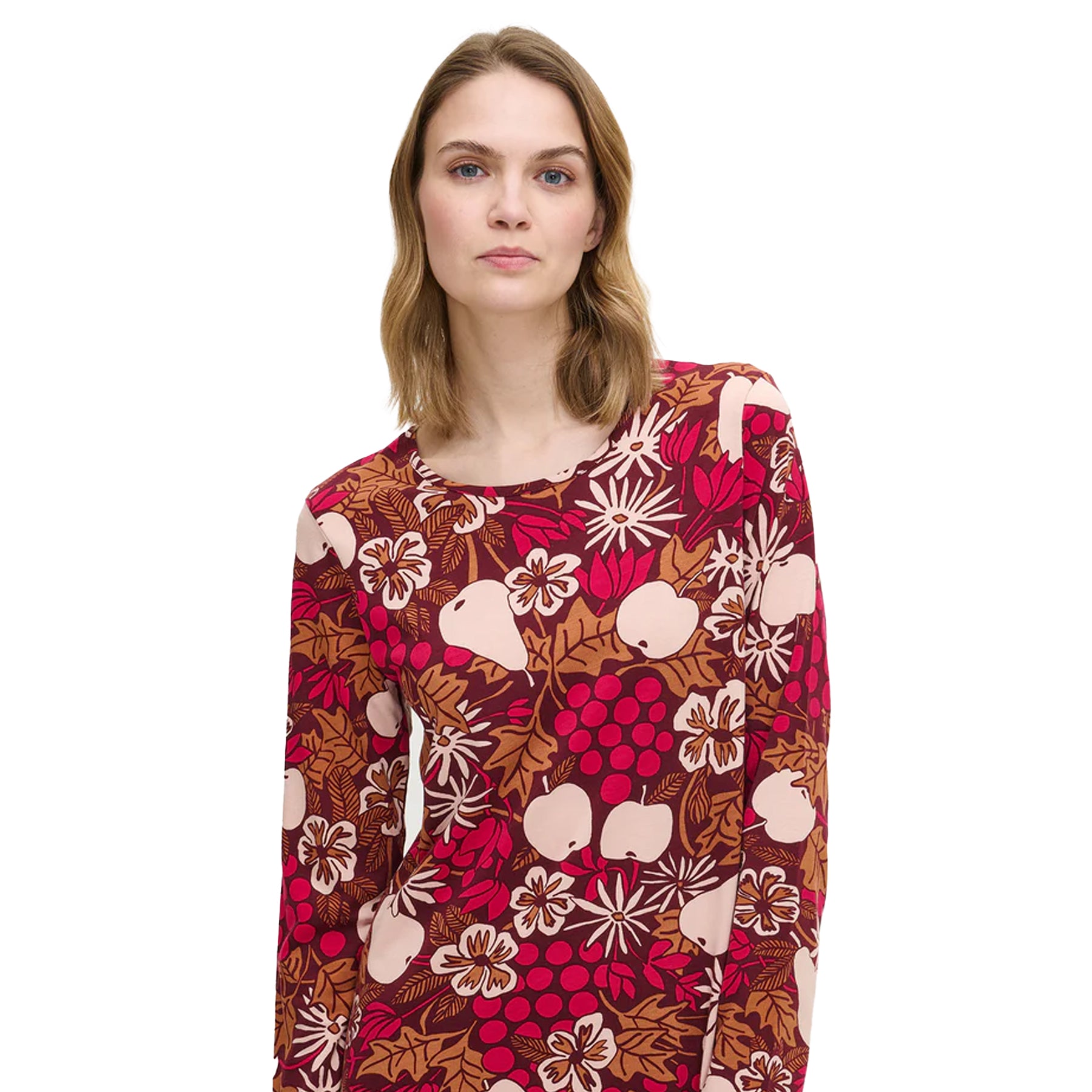 Woman wearing a burgundy cotton nightdress with a multicolour fruit and flower pattern and round neckline detail.