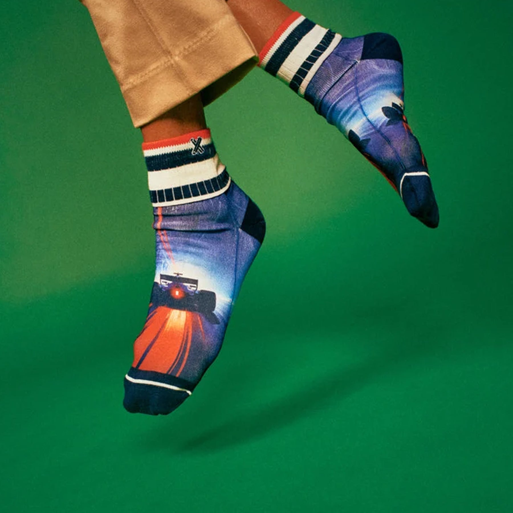 Model wearing race car ankle socks with blue and red racing graphics and sporty striped cuffs.