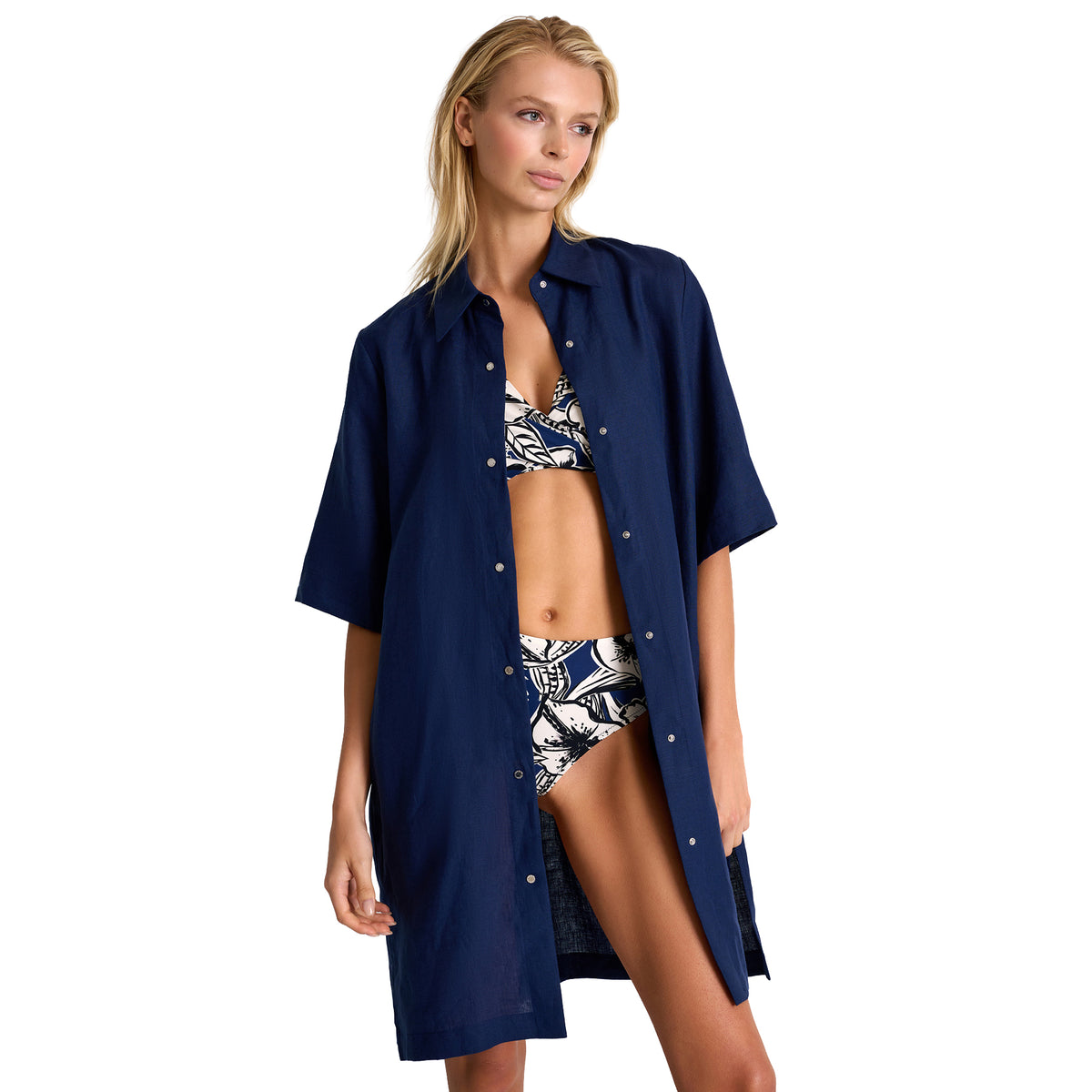 Model wearing SHAN Hibiscus floral bikini set with a navy blue button-front beach cover-up, front view.