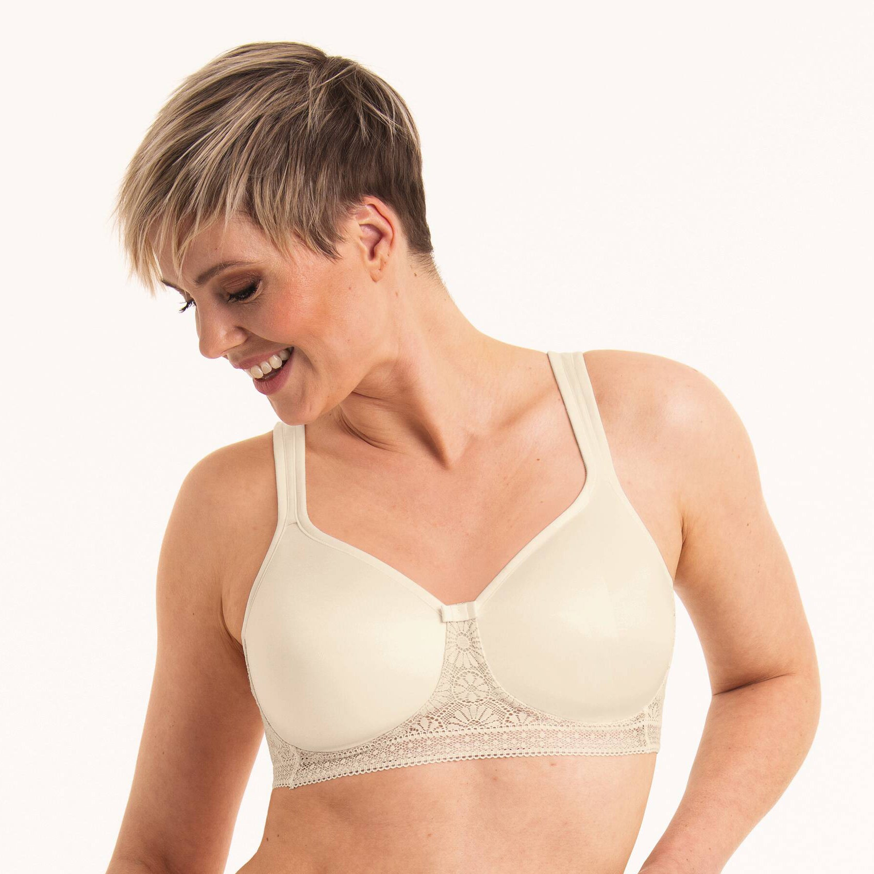Woman wearing ivory full coverage bra with wide straps and lace detail, angled front view