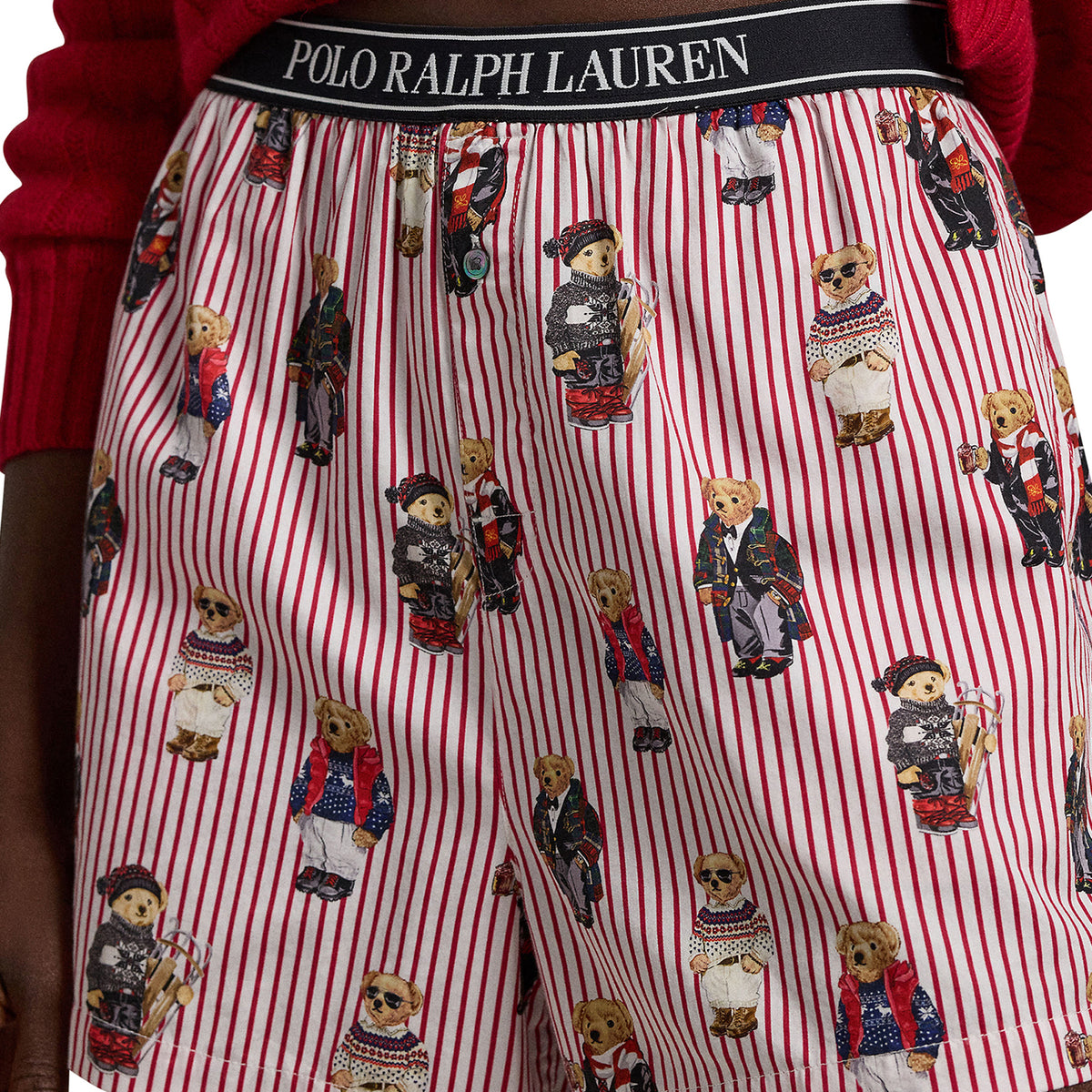 Close-up of Polo Ralph Lauren boxer shorts showcasing the signature Polo Bear print in winter outfits, red and white stripes, and a black elastic logo waistband.