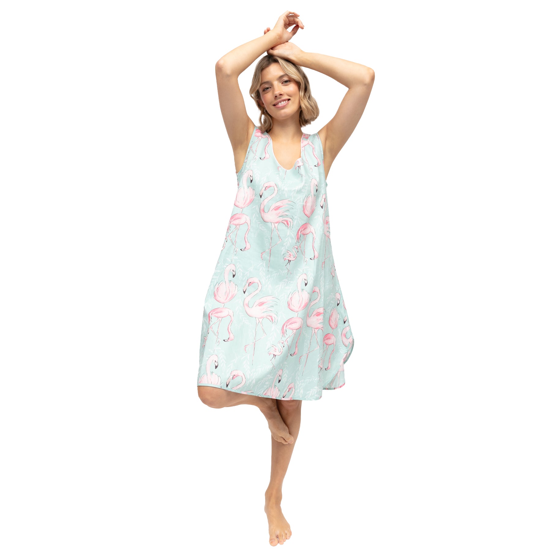 Woman posing in mint flamingo print chemise with flowy silhouette and playful tropical print