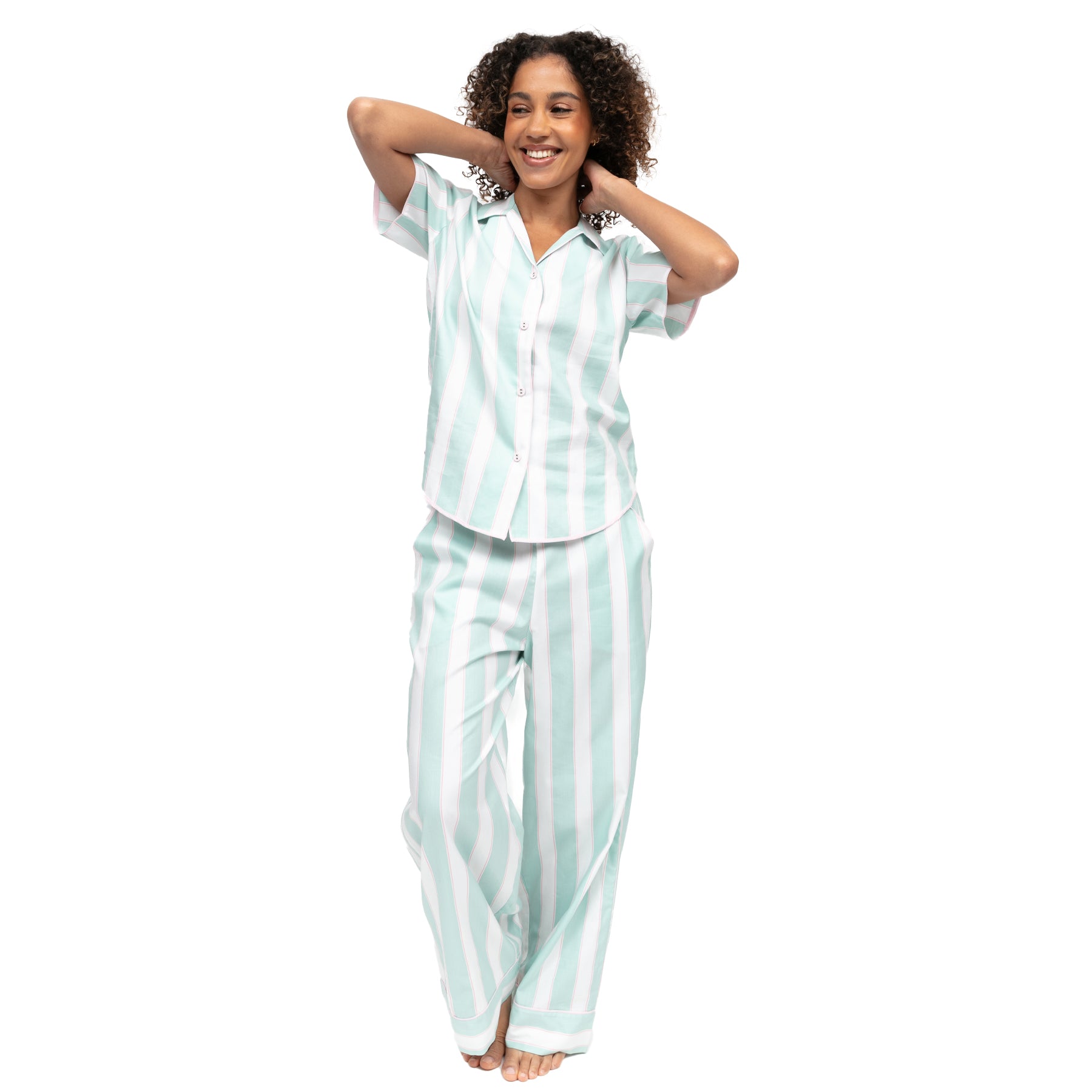 Woman wearing mint green striped pajama set with short sleeve button-up top and relaxed fit pants