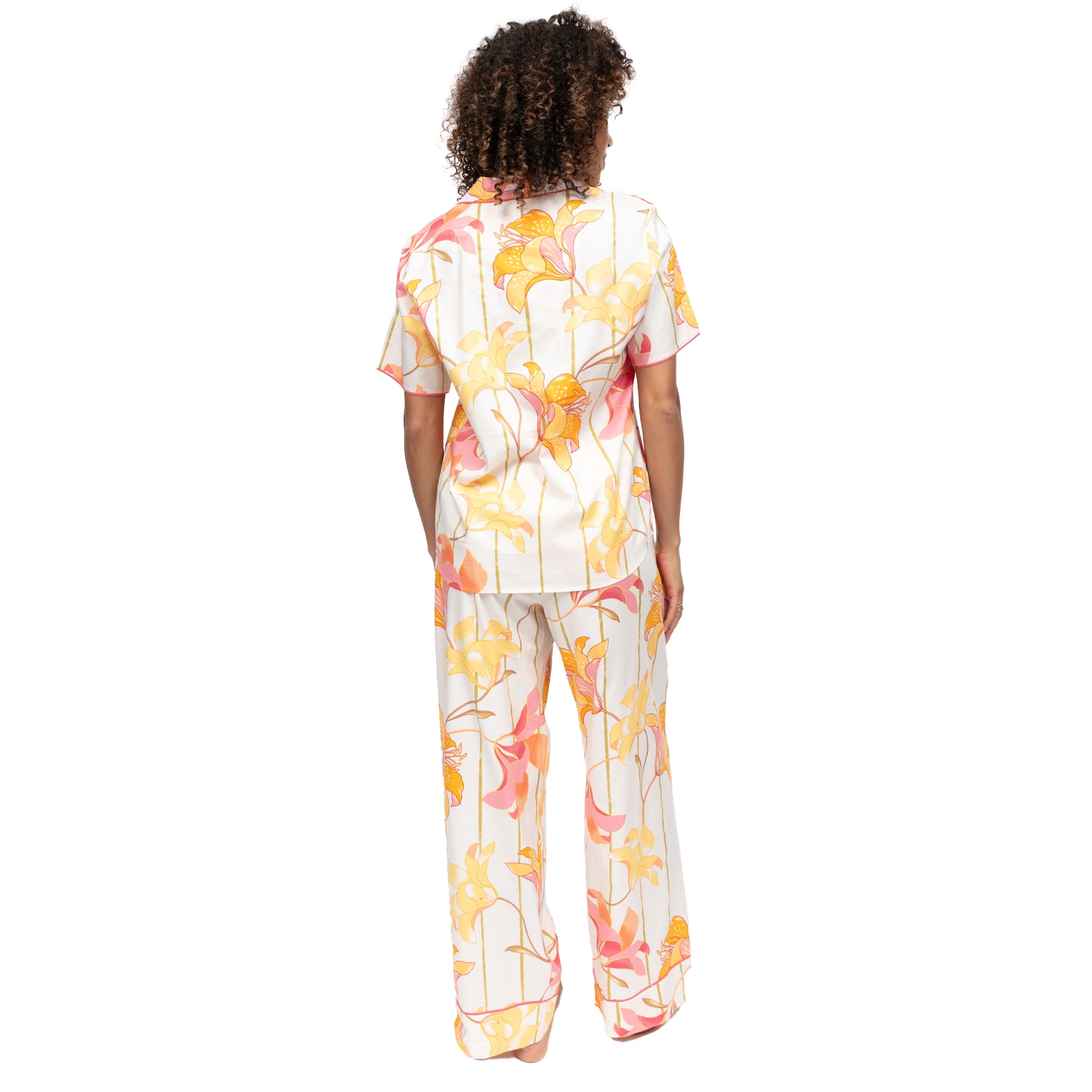 Back view of women’s floral pyjama set with short sleeve top and wide-leg pants in white with yellow and coral lily print