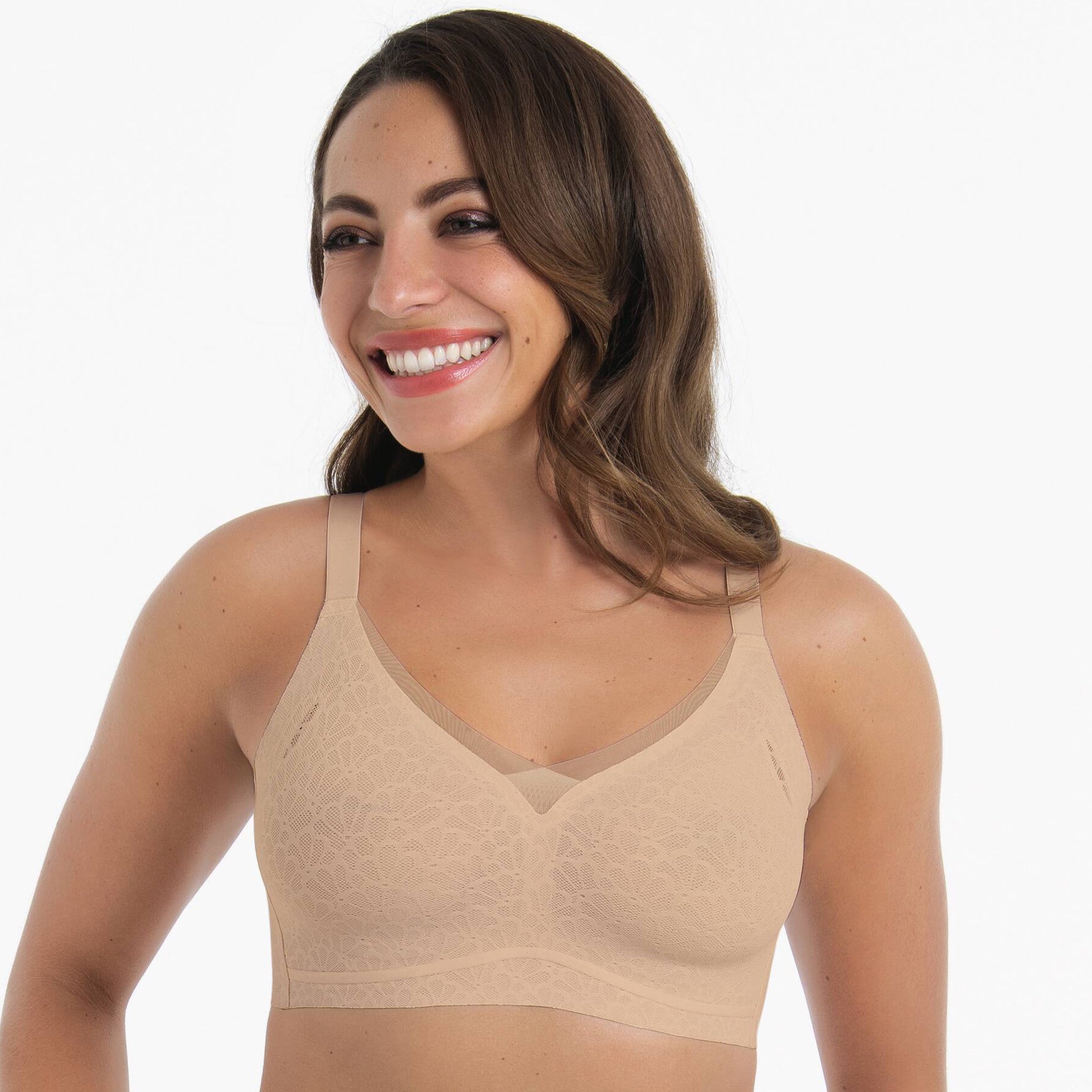 Front view of wireless nude lace bra with light support, wide straps, and seamless finish on model