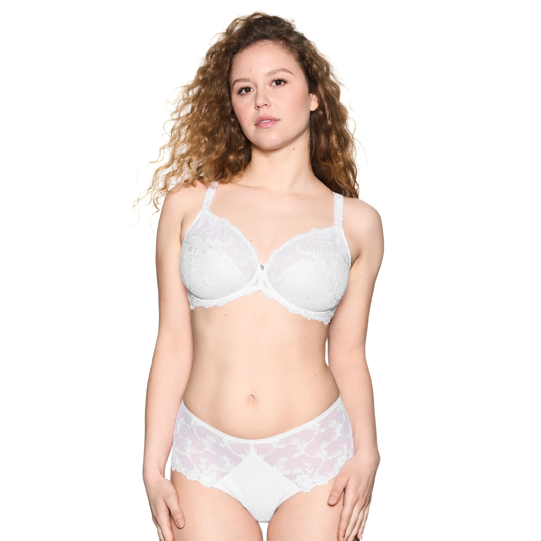 Woman wearing white lace underwire bra and matching brief, elegant floral embroidery and supportive fit