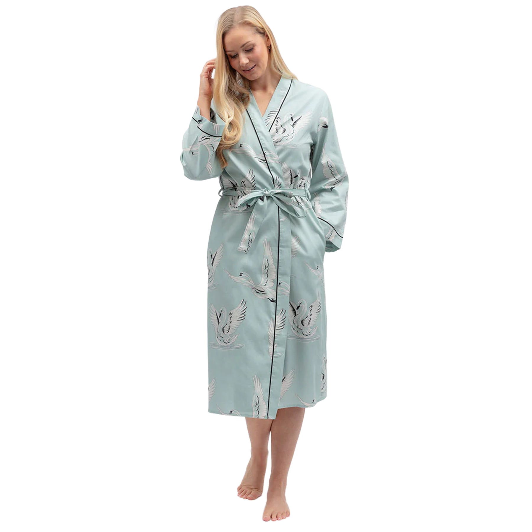Woman wearing a mint blue cotton robe with elegant swan print, wrap front design, waist tie belt and black contrast piping.