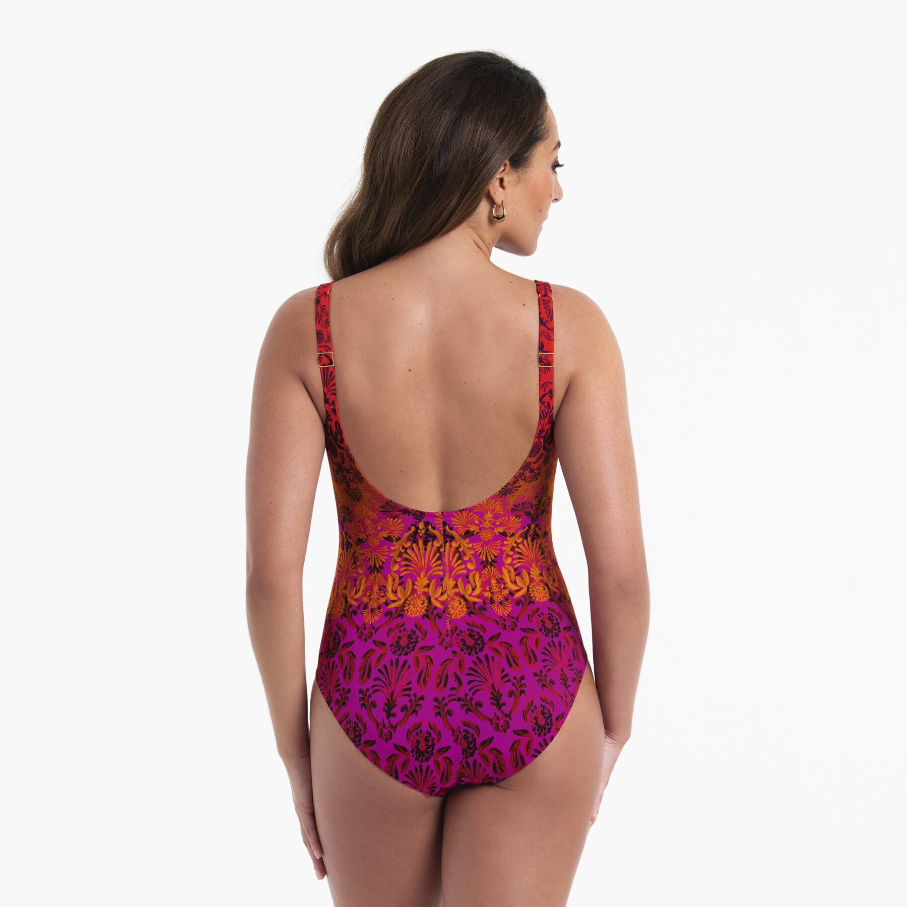 Back view of a one-piece swimsuit in red, orange and fuchsia ombré floral print with adjustable straps and low scoop back.