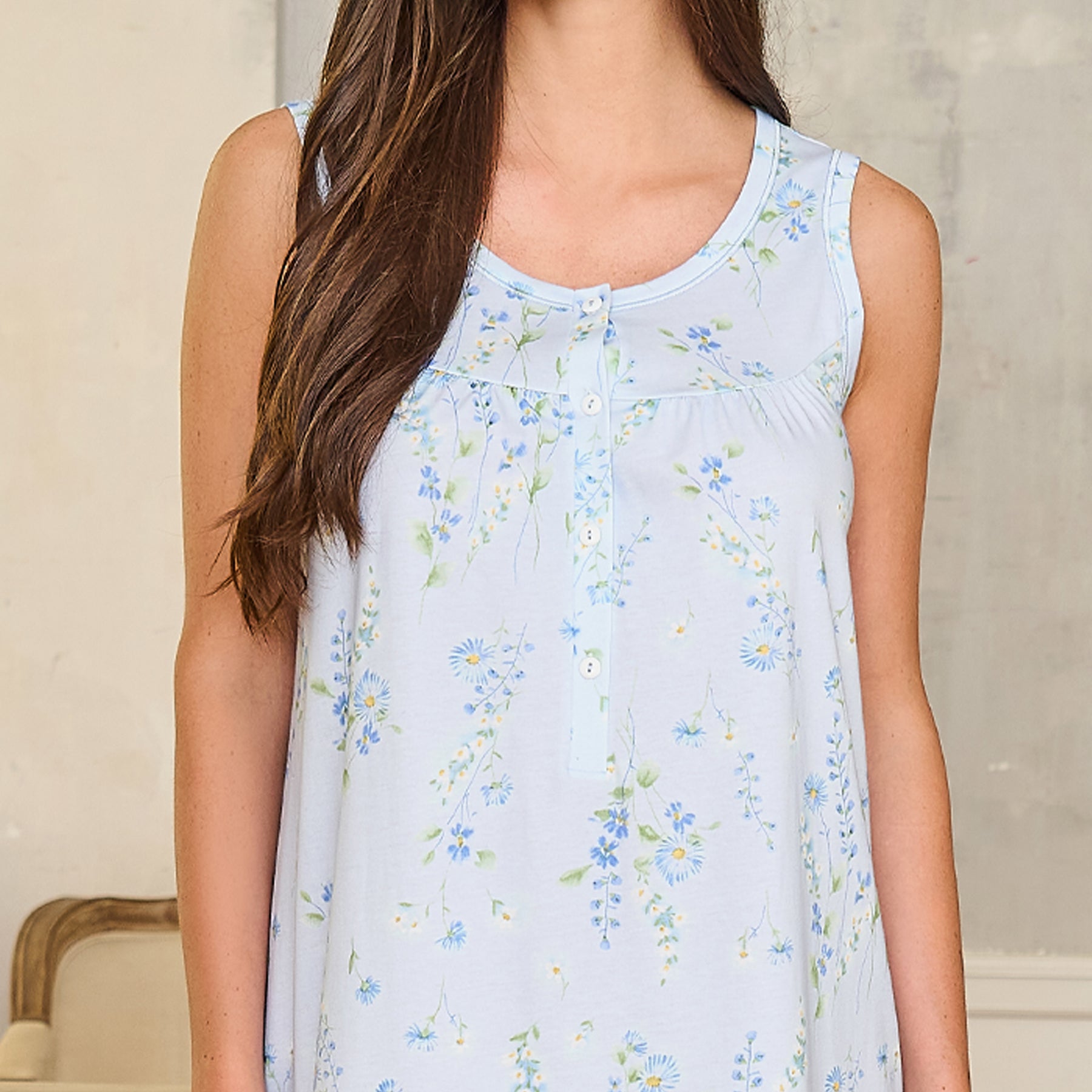 Close-up of light blue nightgown with dainty floral pattern and button placket detail on breathable, smooth fabric