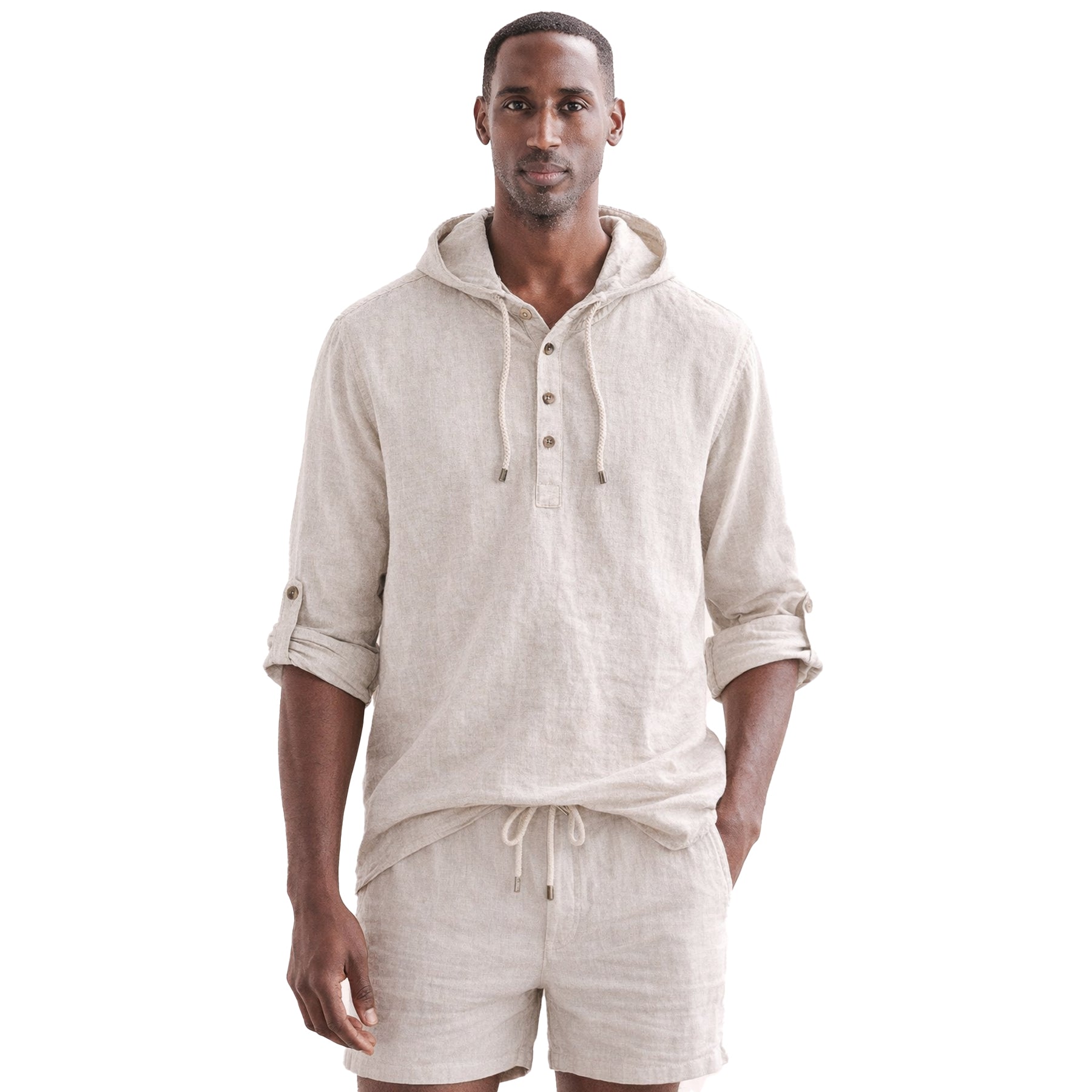 Male model wearing a beige hooded linen shirt with rolled sleeves and matching shorts, styled for a relaxed summer look.