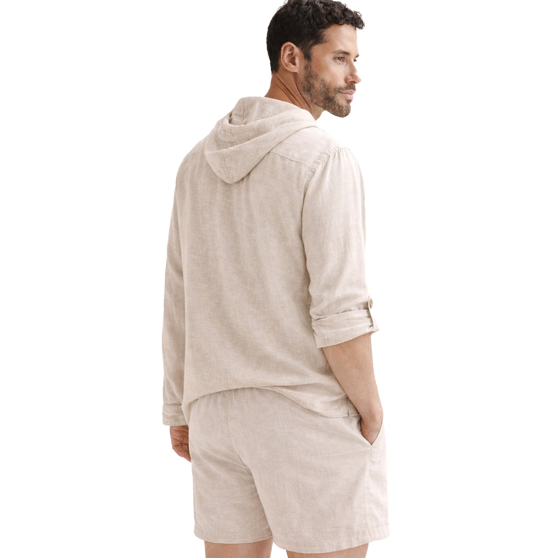 Back view of a male model wearing a beige hooded linen shirt with long sleeves and matching linen shorts on white background.