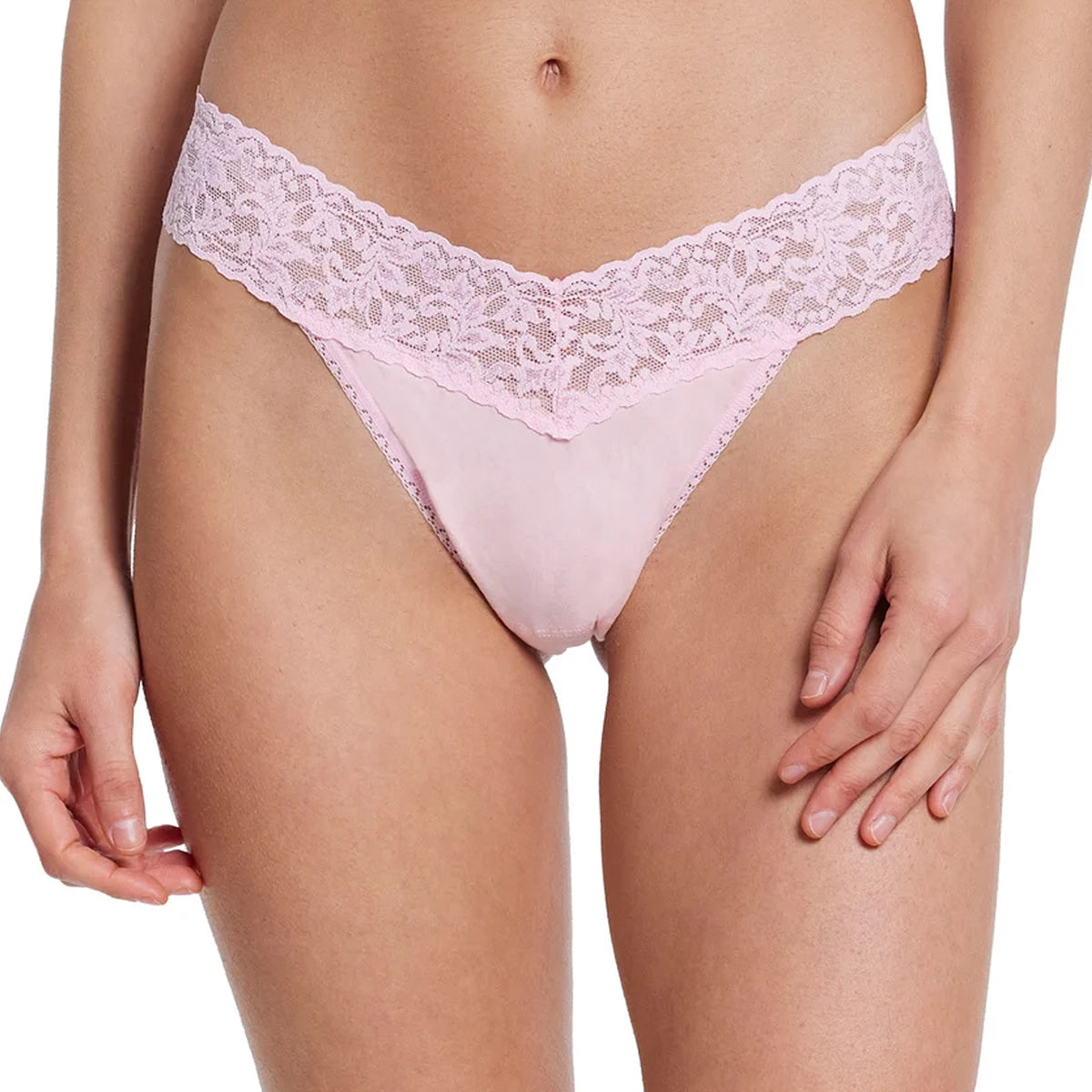 Close-up front view of the Hanky Panky Supima Cotton Original Rise Thong in Bliss Pink, featuring a smooth pale pink cotton front panel, wide floral lace waistband, and scalloped lace detailing.