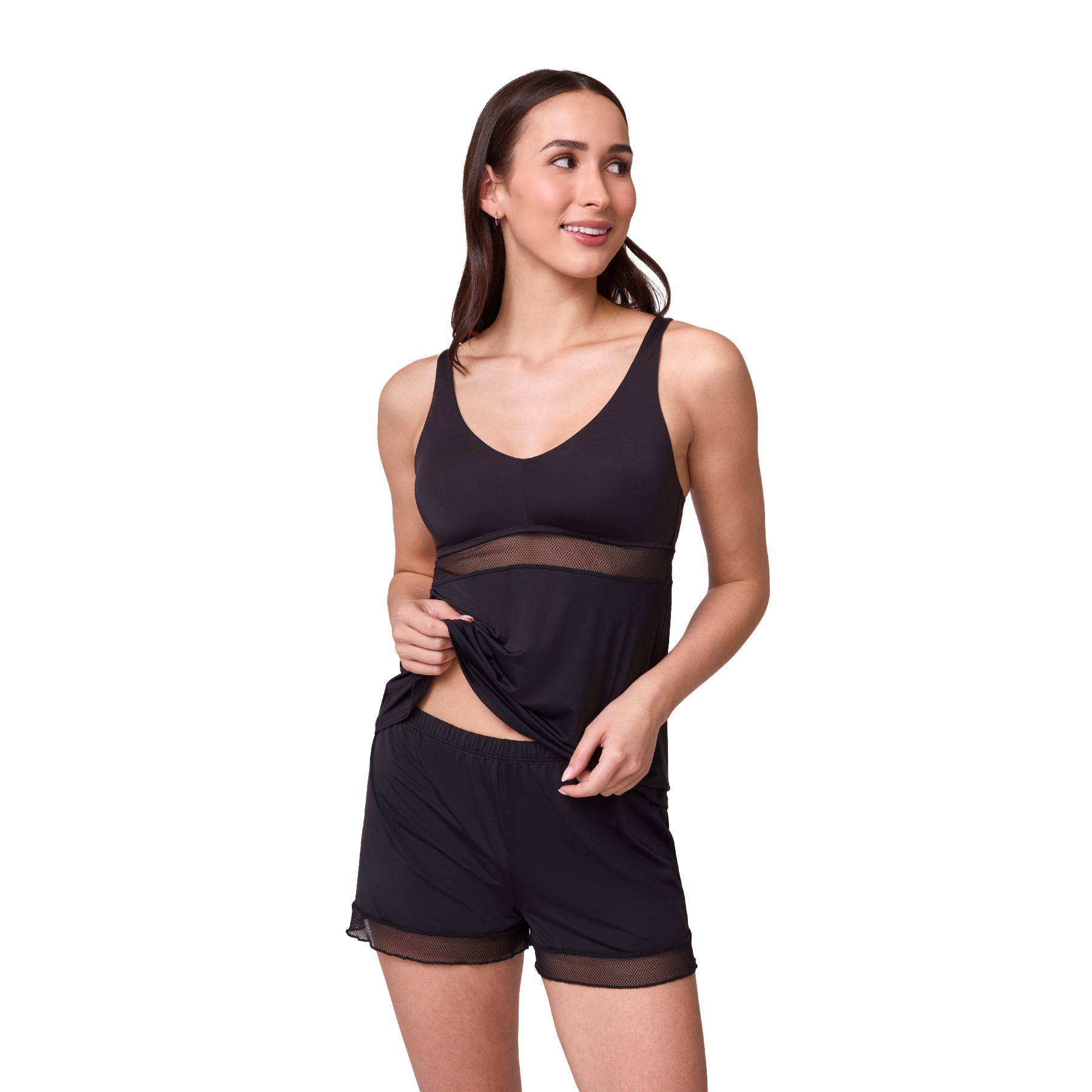 Model lifting black camisole slightly to show matching black lounge shorts with sheer mesh hem detail.