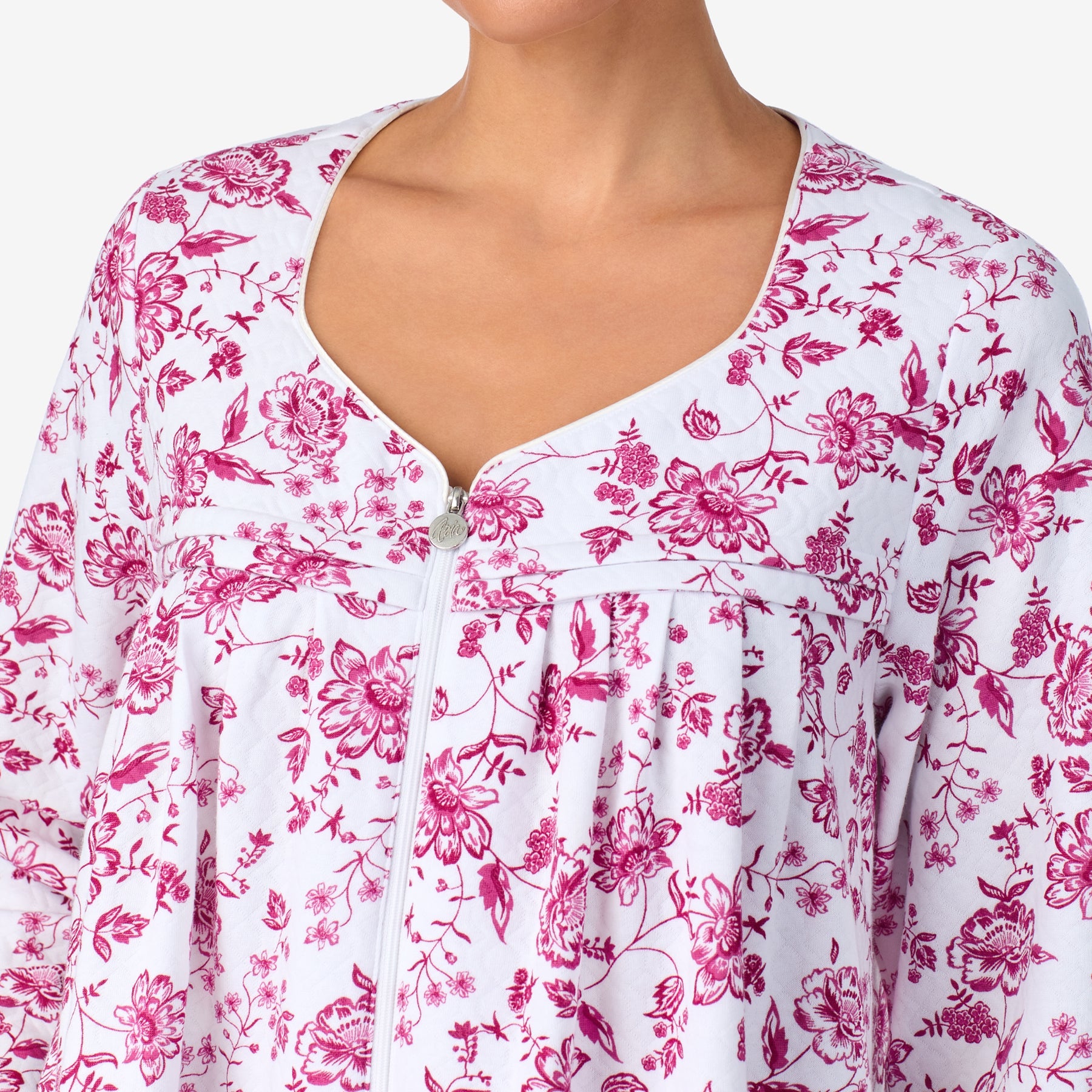 Close-up of a white cotton nightgown with pink floral print and front zipper.