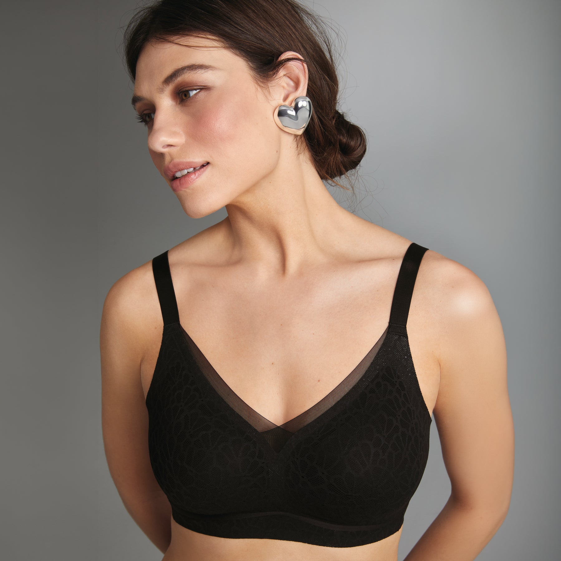 Front view on model of Anita 5433 Essential Smart bralette wireless bra with subtle floral texture and smooth band in black.