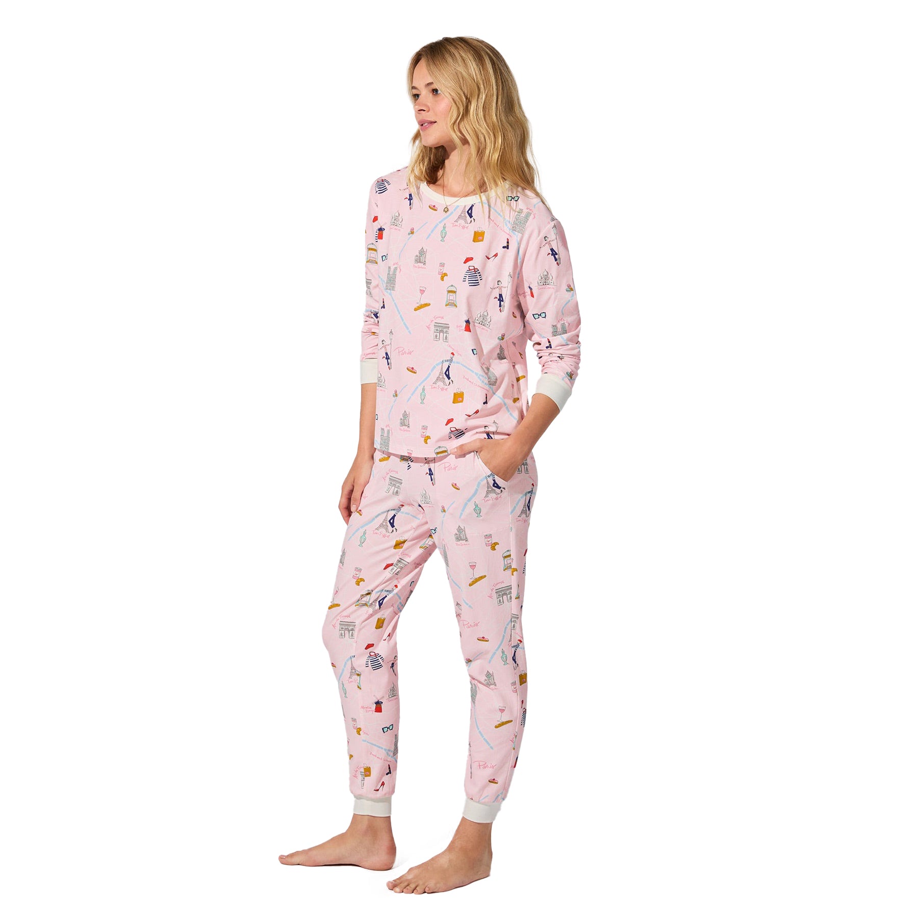 Side view of straight-size model wearing pink Paris print pajama set with white ribbed cuffs.