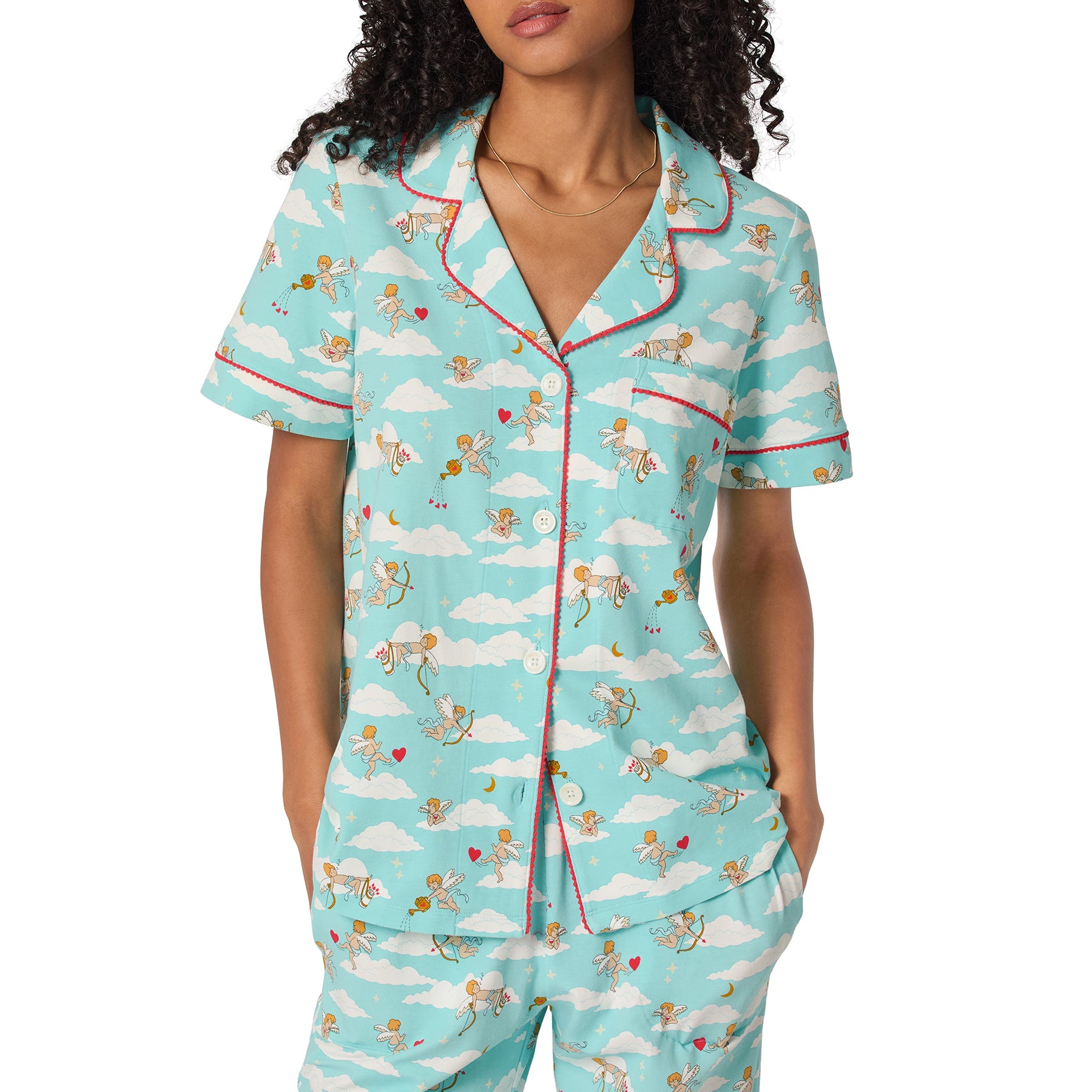 Woman wearing a light blue pajama set with cloud and character pattern on a white background