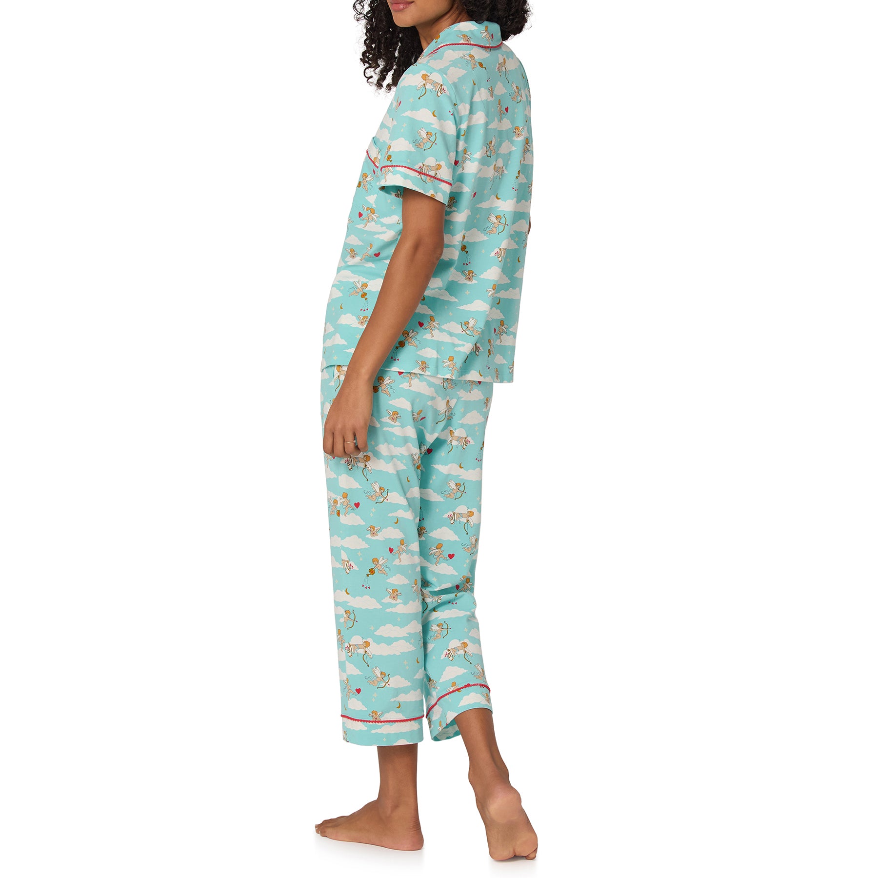 Woman wearing a blue pajama set with a cloud and star pattern on a white background