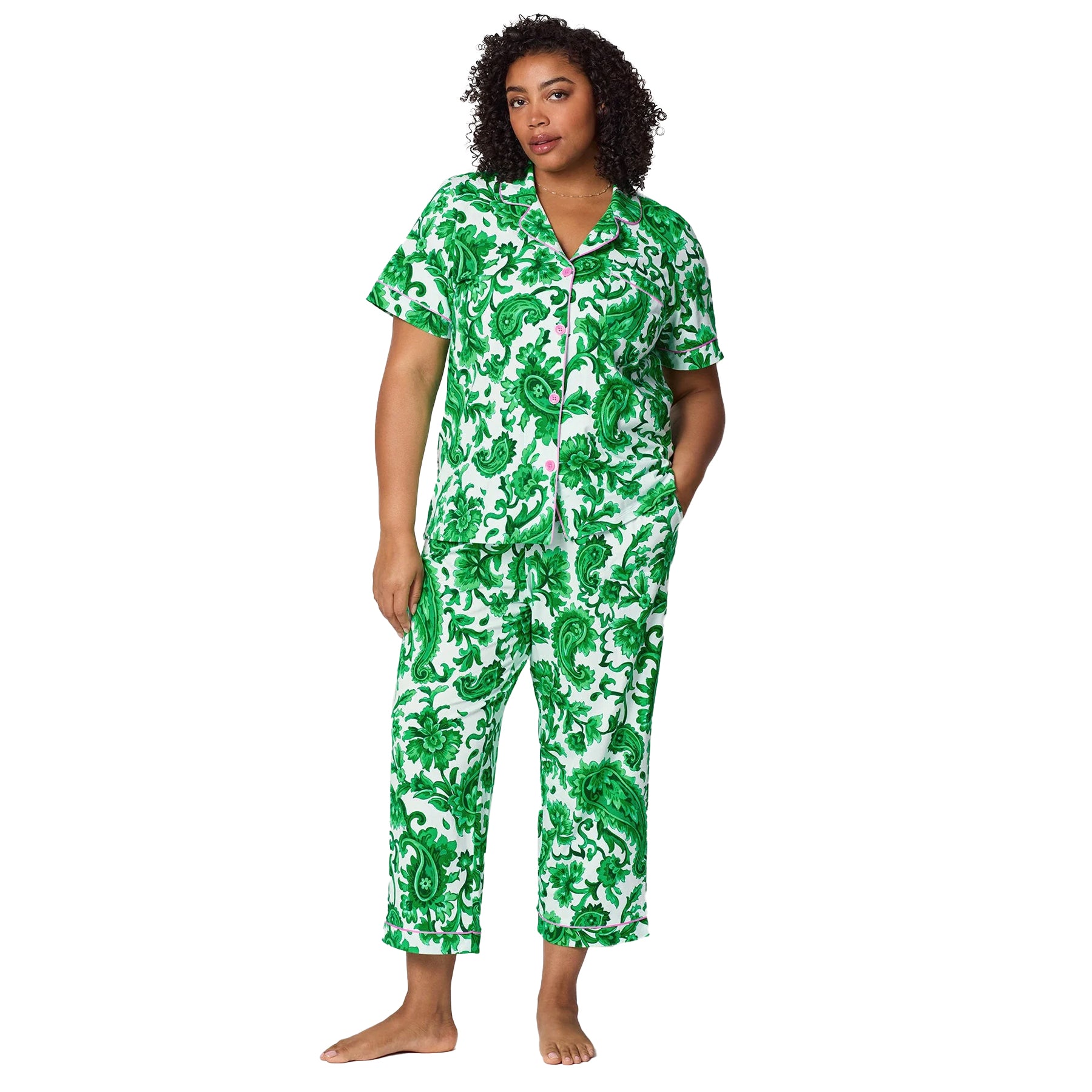 Curvy model wearing green floral print pyjama set with pink trim and soft comfortable silhouette.