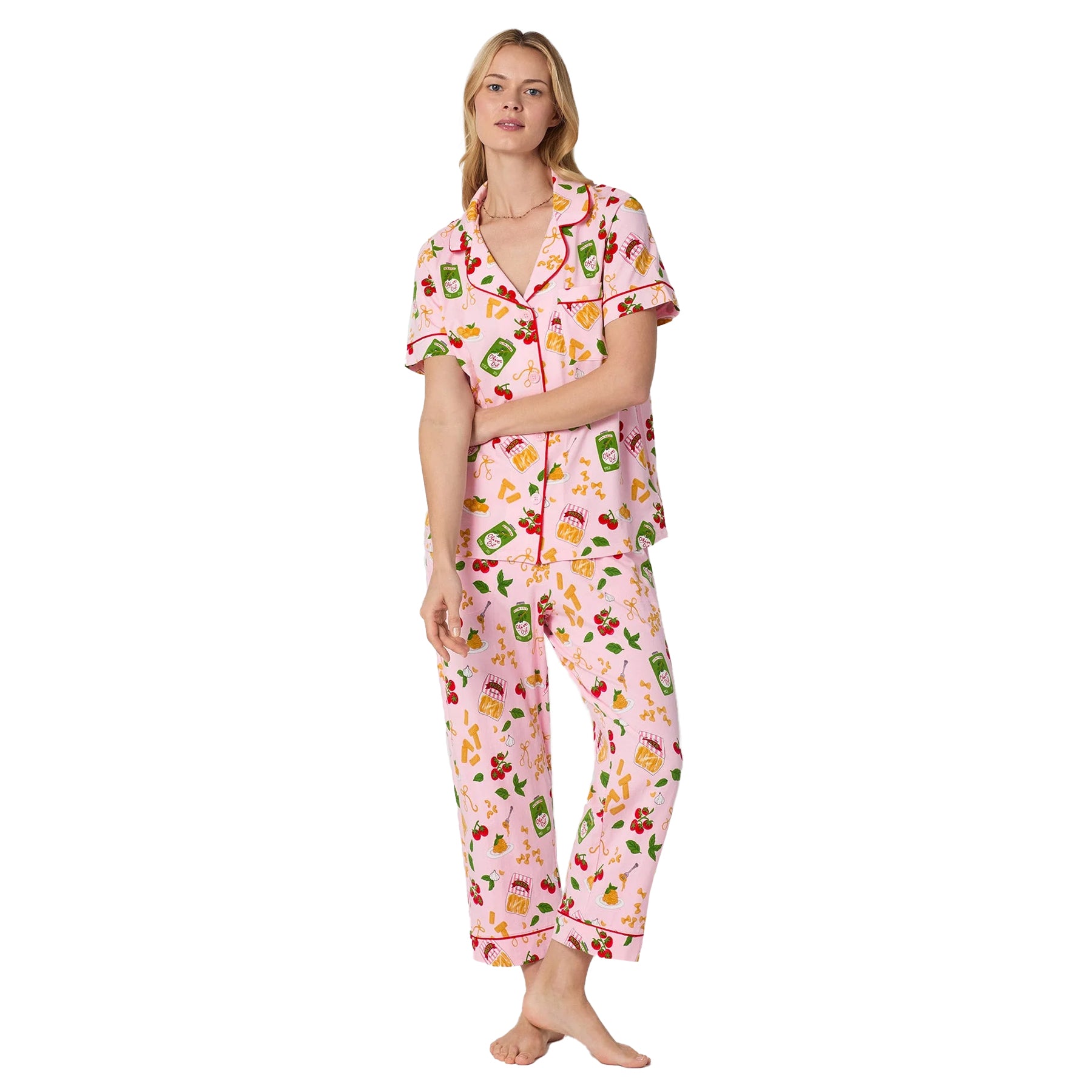 Woman wearing Bedhead pink Italian food print pajama set with cropped pants and short sleeve button-up PJ top.