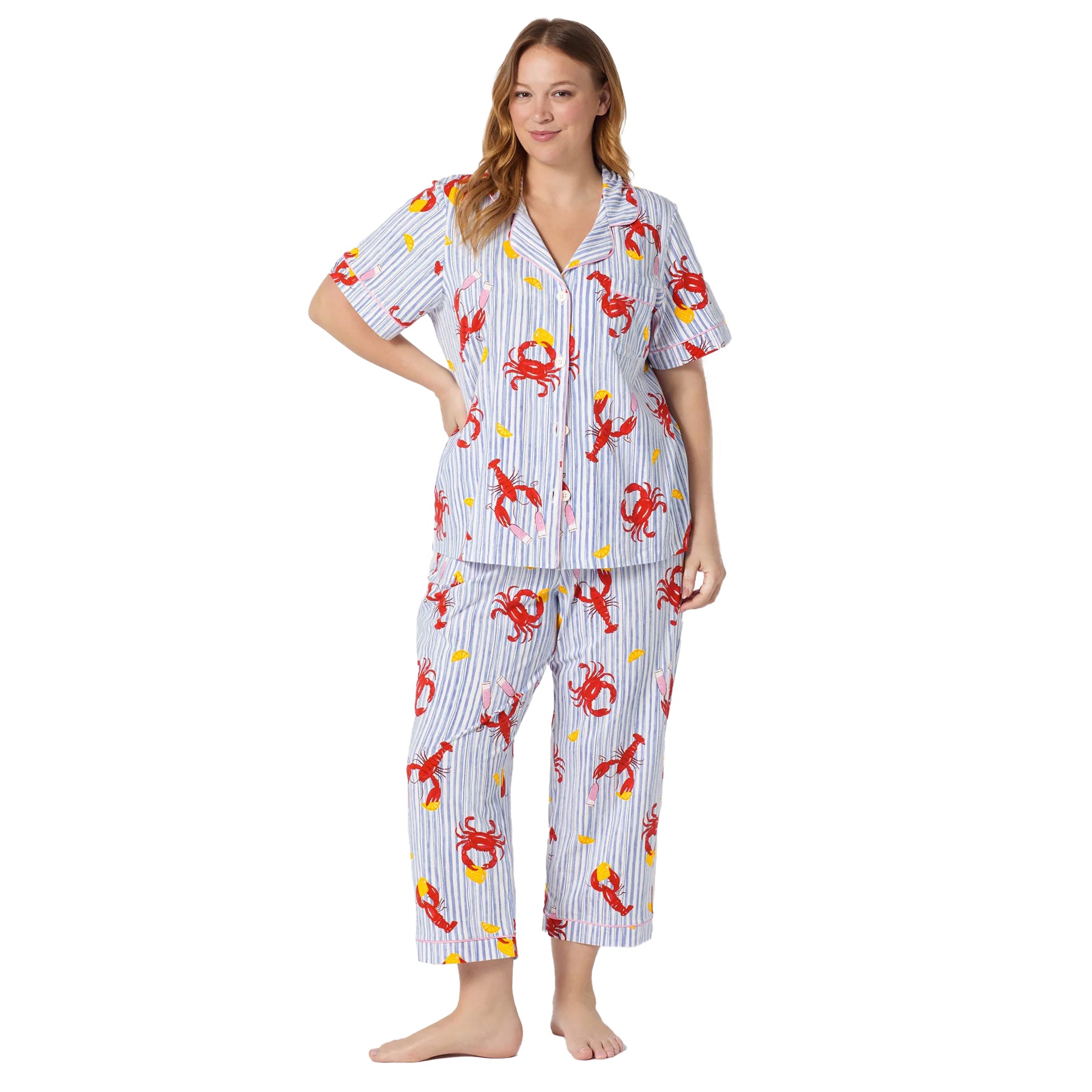 Plus size model wearing a blue striped coastal-inspired pyjama set with lobster print, button-front top, and relaxed cropped pants.
