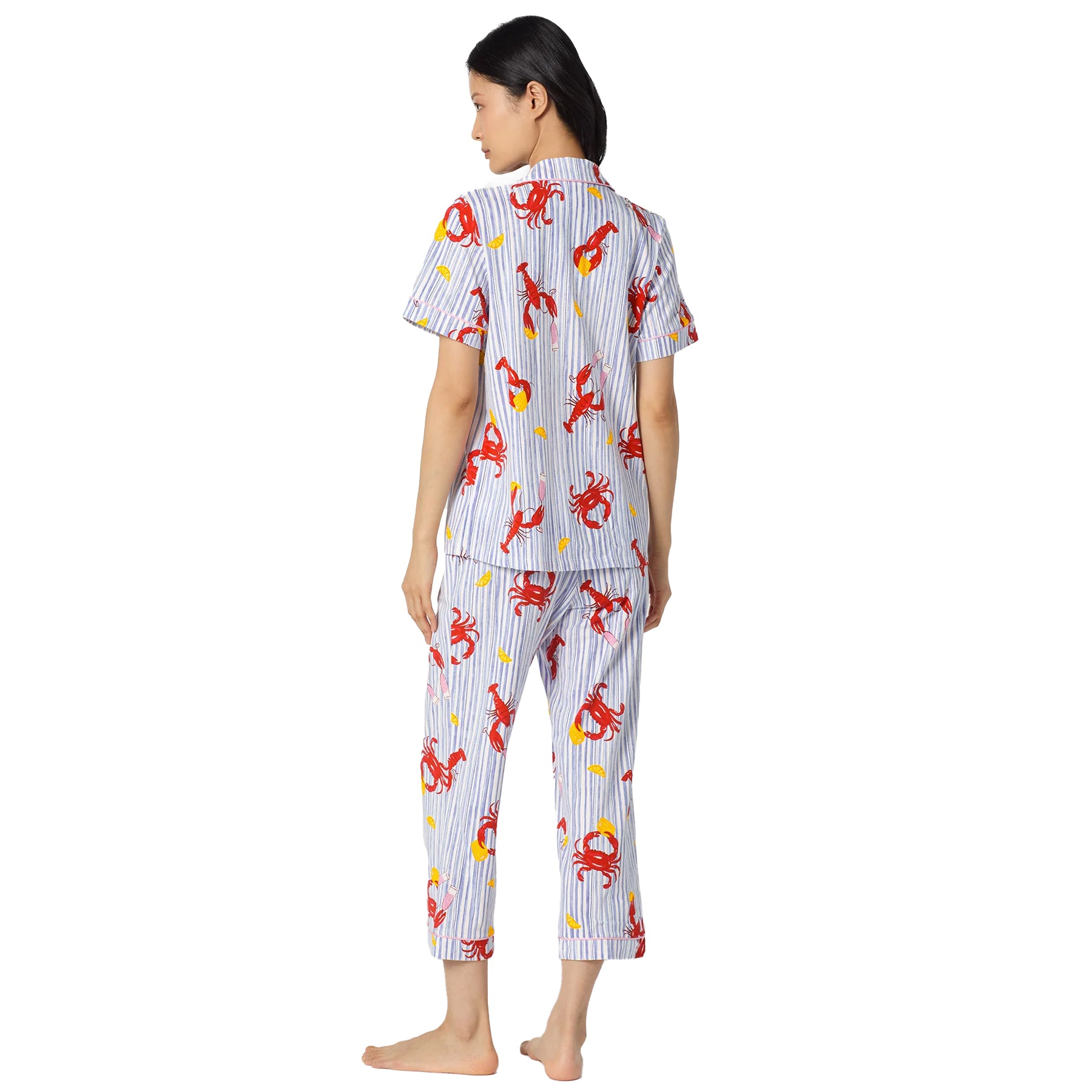 Side back view of a nautical-inspired striped pyjama set with red lobster motifs, short sleeve top, and cropped straight-leg pants.