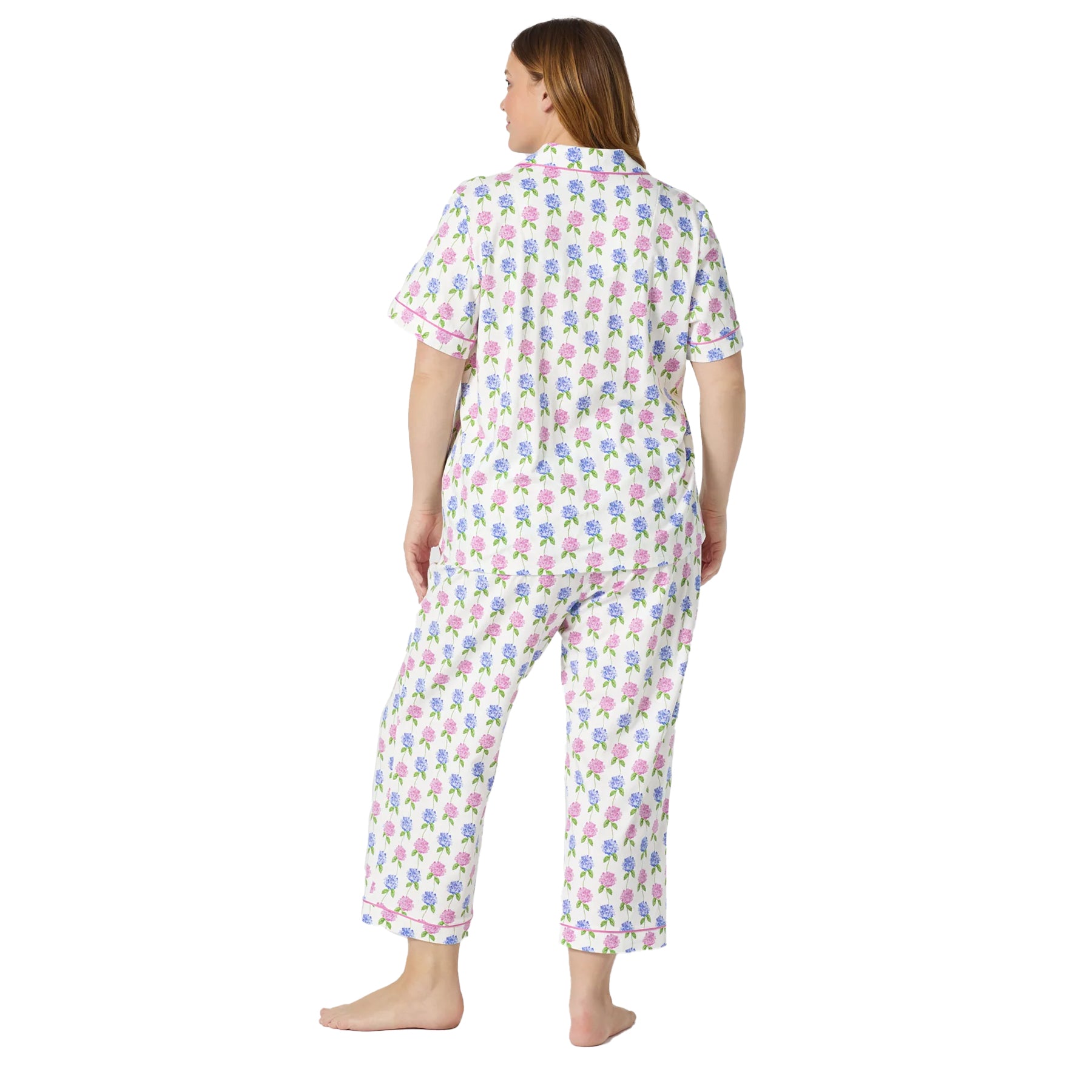 Back view of a white floral pyjama set with pastel hydrangea print, relaxed short sleeve shirt, and cropped lounge pants with pink trim.