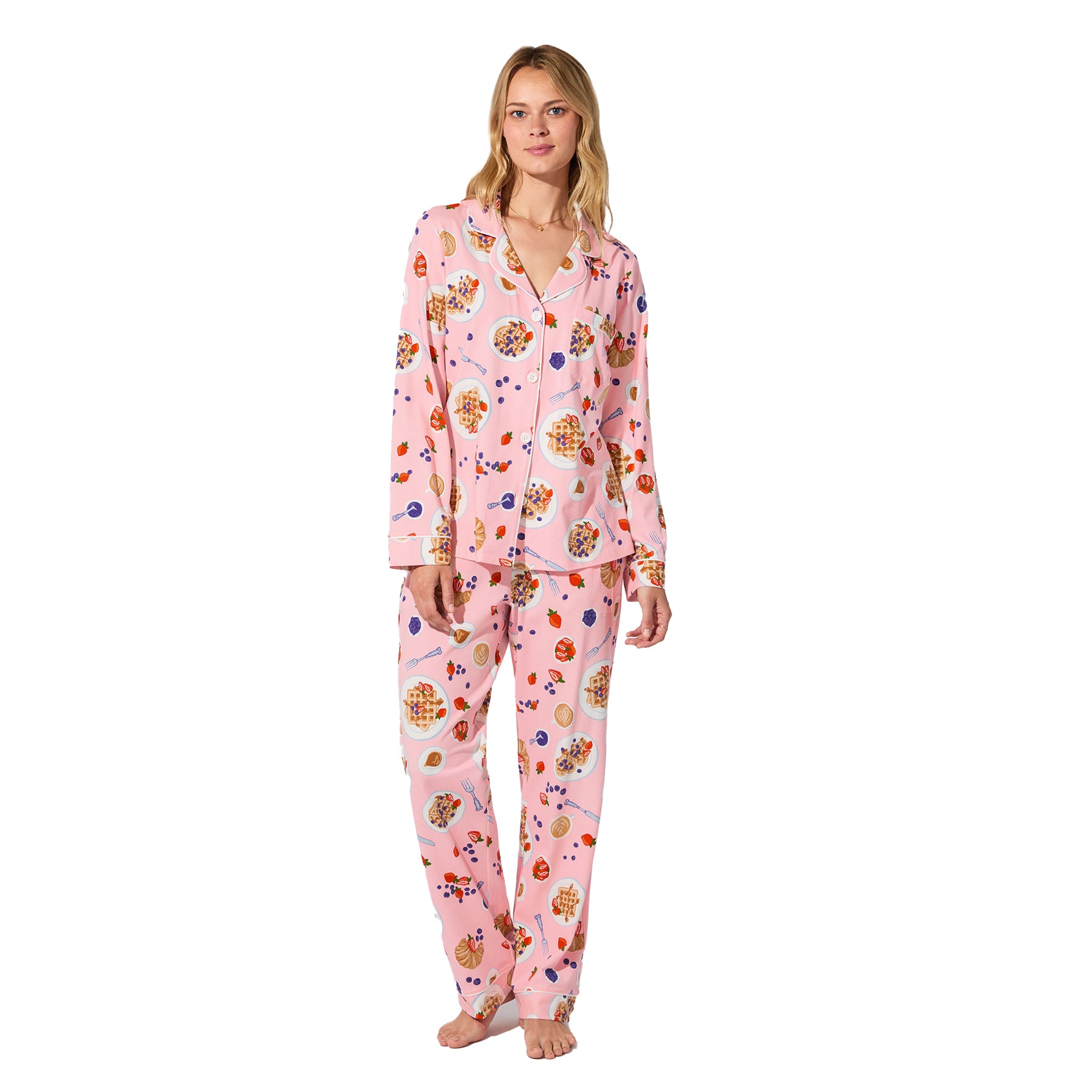 Full view of woman wearing pink waffle brunch print pyjama set, long sleeves and pants.