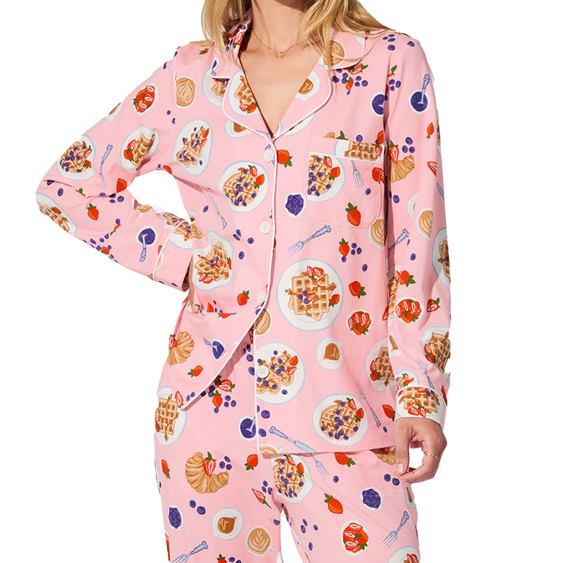 Detail shot of pink waffle brunch print pyjama shirt with waffles, berries, croissants, and coffee illustrations.
