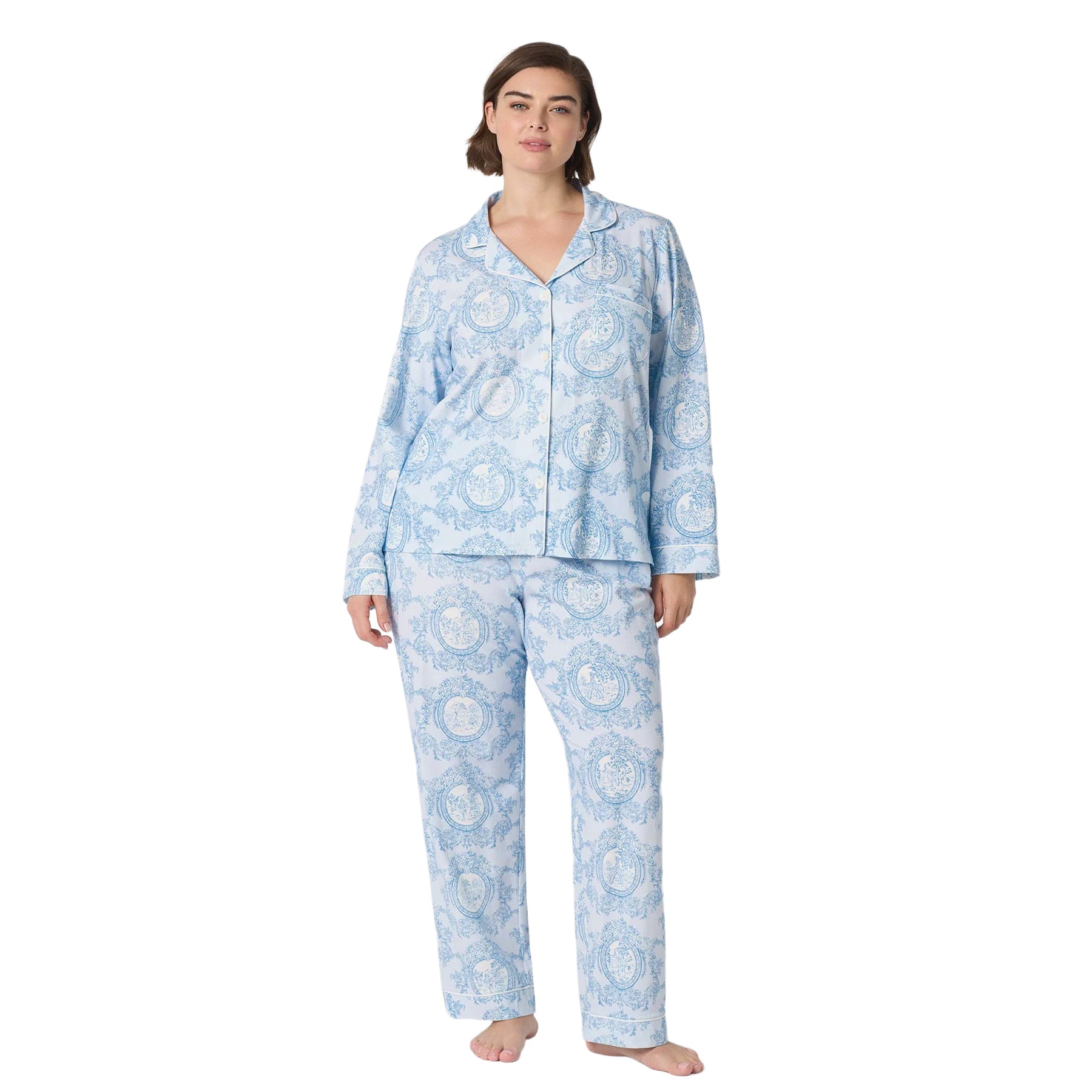 Plus-size woman wearing a light blue toile-print pajama set with a button-front long-sleeve top and full-length pants.