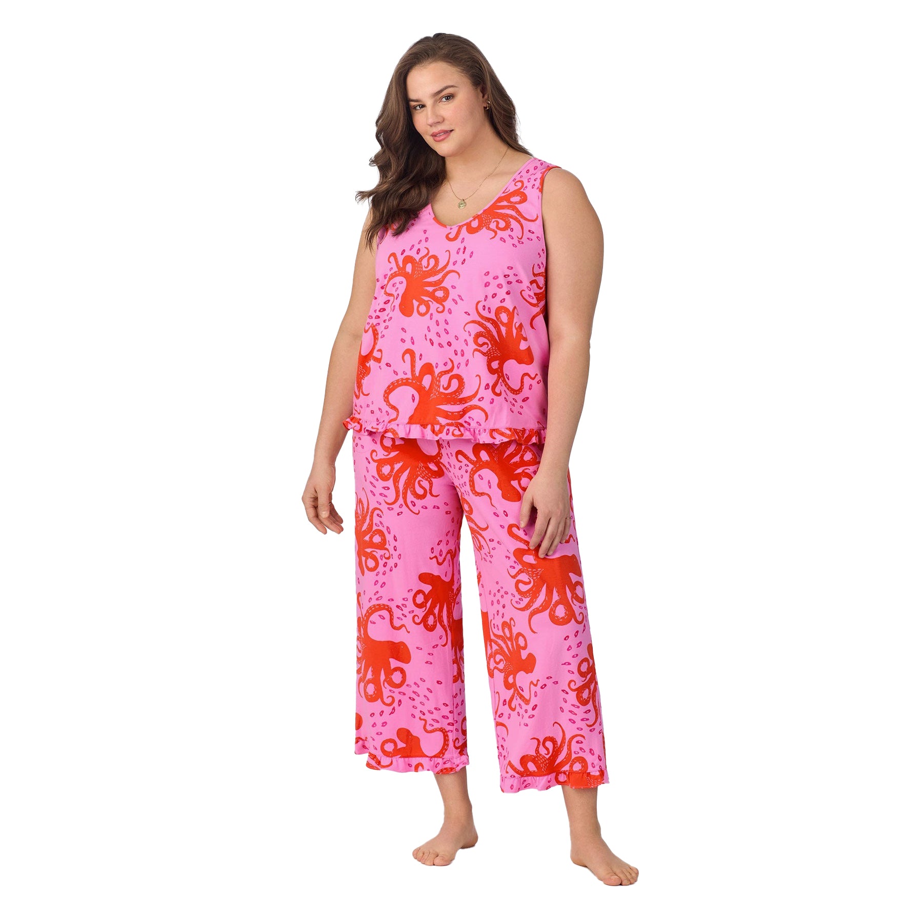 Plus-size model in a sleeveless top and wide-leg pants featuring a bright octopus print in coral on pink.